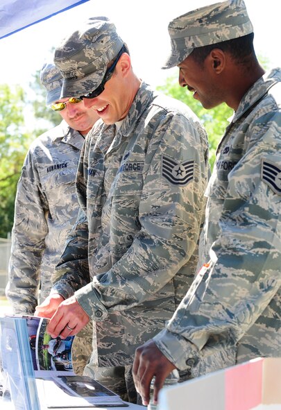 MOODY AIR FORCE BASE, Ga.--  Tech. Sgt. Jason Kotterman, 23rd Equipment Maintenance Squadron aircraft structure maintenance craftsman, looks through a photo album of a fishing trip he attended at Banks Lake National Wildlife Refuge March 25. Banks National Wildlife Refuge is one of the many booths that were displayed at the Outdoor Extravaganza event. (U.S. Air Force photo/Senior Airman Stephanie Mancha)(RELEASED)