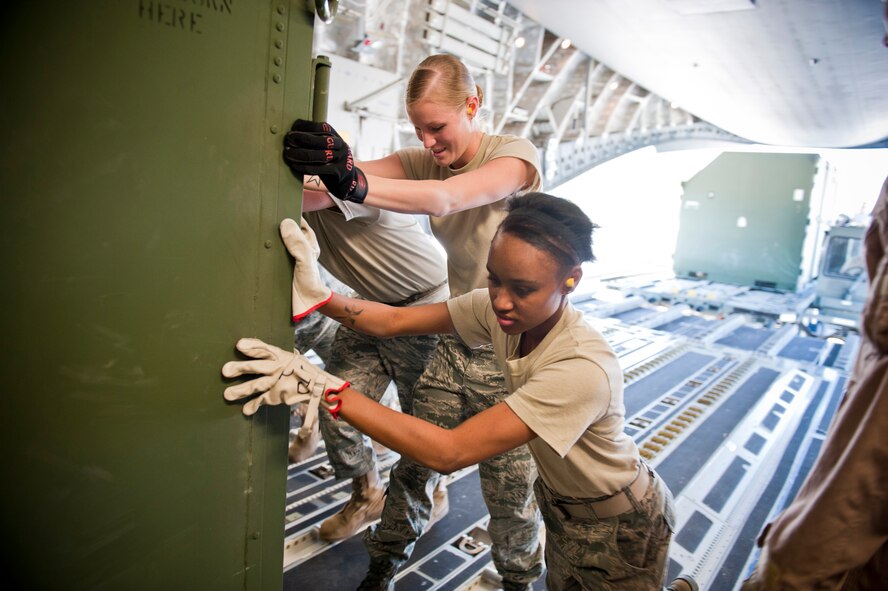 MOODY AIR FORCE BASE, Ga. -- Senior Airman Brittany Bonhorst, 23rd Logistics Readiness Squadron supply journeyman, and Airman 1st Class LaTosha Ross, 23rd LRS supply apprentice, help secure cargo to a C-17 Globemaster III March 24 at Moody Air Force Base, Ga. For large loads, the 23rd LRS uses augmentees from various sections within the unit to assist in completing the mission. (U.S. Air Force photo/Staff Sgt. Jamal D. Sutter)