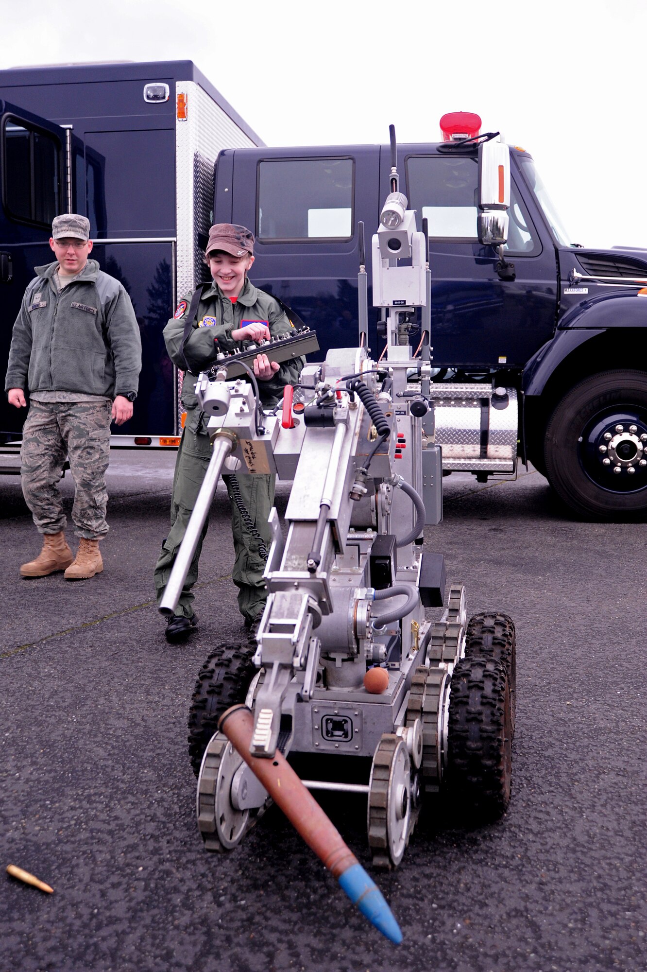 Josh Loux, 14, operates a robot with the help of Airman 1st Class Evan Grimme, 627th Civil Engineer Squadron’s explosive ordnance disposal unit, as part of the ‘Pilot for a Day’ program March 18, 2011, at Joint Base Lewis-McChord, Wash.  (U.S. Air Force photo/Adamarie Lewis-Page)