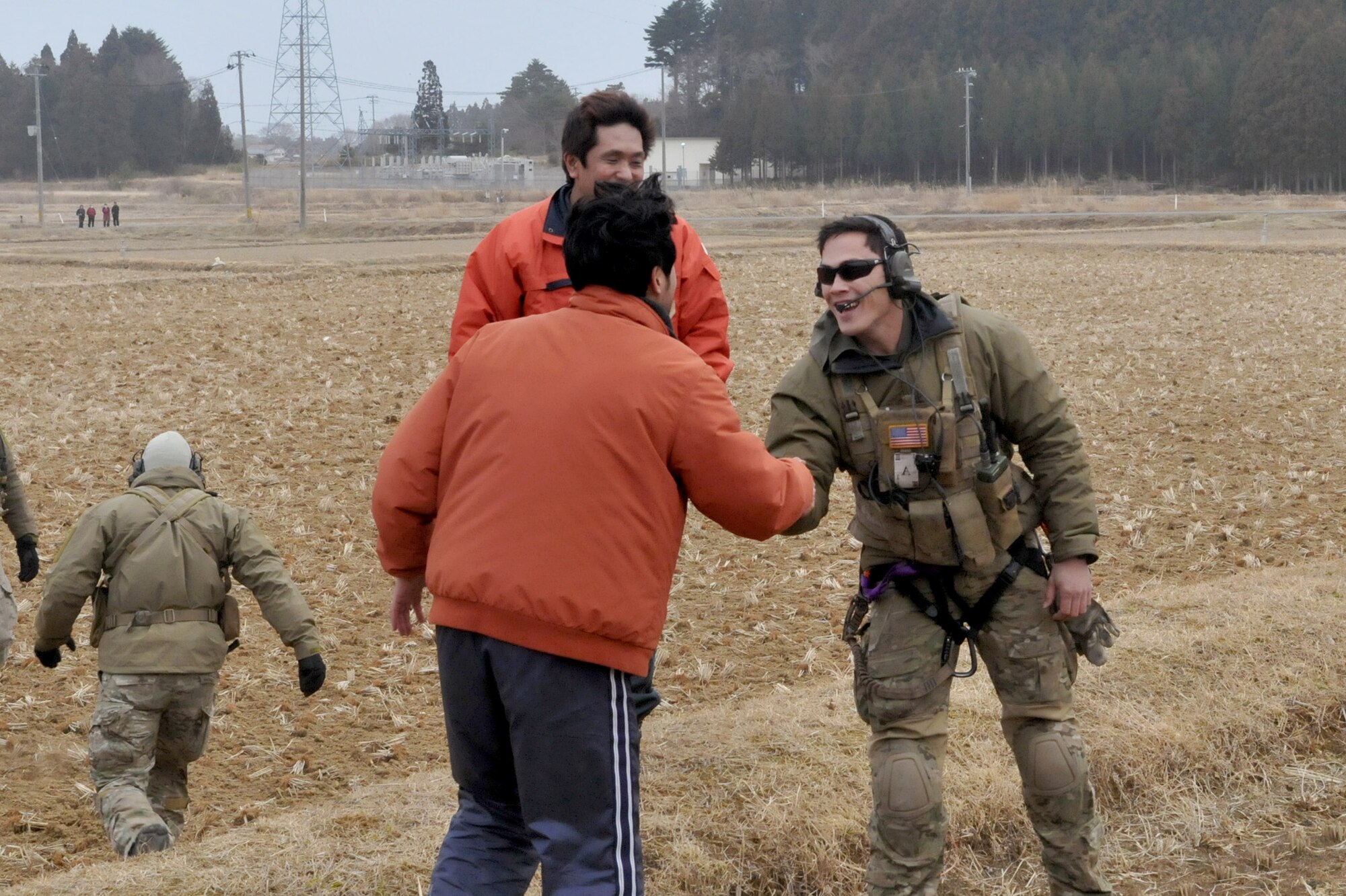 An Airman speaks with Japanese relief workers after HH-60 Pave Hawk crewmembers delivered food, water and medical supplies March 20, 2011, for displaced people in Kessenuma City, Japan. (U.S. Air Force photo/2nd Lt. Christopher Love)