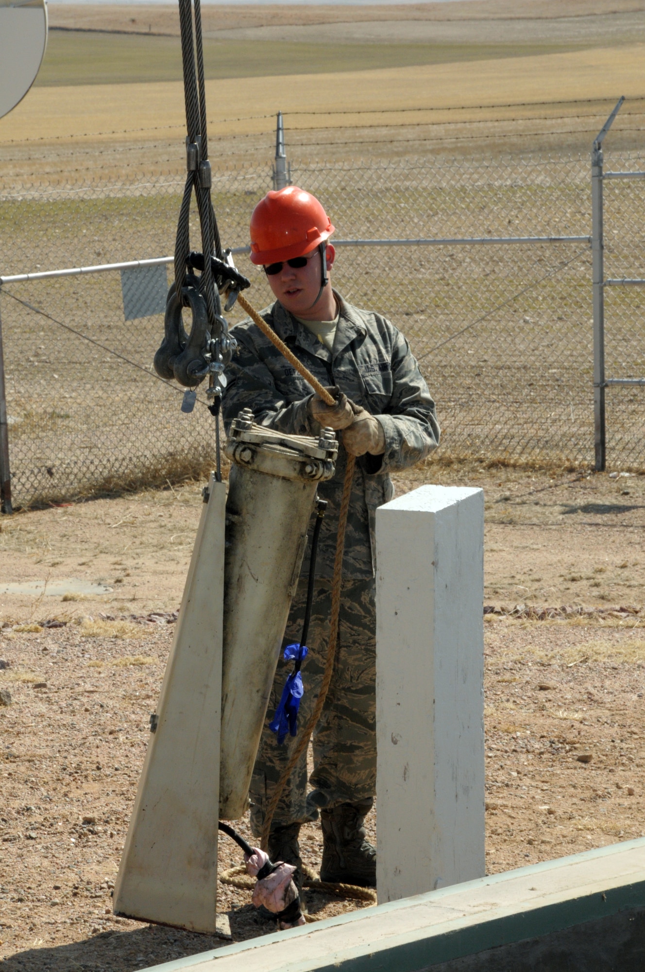Airman 1st Class Andrew Oetzel, 90th MMXS, guides the removal of the old bypass oil filter during the replacement of the launch facilities back-up power supply March 18. (U.S. Air Force photo by Blaze Lipowski)