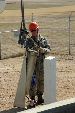 Airman 1st Class Andrew Oetzel, 90th MMXS, guides the removal of the old bypass oil filter during the replacement of the launch facilities back-up power supply March 18. (U.S. Air Force photo by Blaze Lipowski)