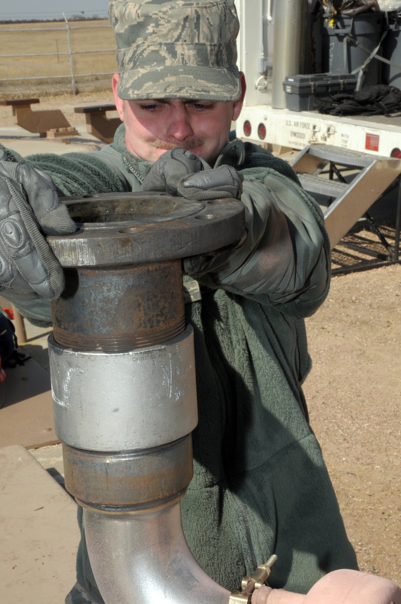 Senior Airman David Reynolds, 90th MMXS, installs the exhaust shroud on the new diesel engine before lowering it into position as the launch facilities back-up power supply March 18. (U.S. Air Force photo by Blaze Lipowski)