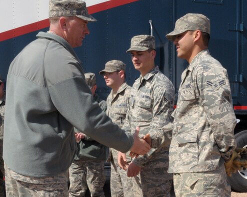 Col Greg Tims, 90th Missile Wing commander, coins Airman 1st Class Mark Carrier, 90th MMXS, for the outstanding job in the field, contributing to the replacement of the diesel engine units March 18. (U.S. Air Force photo by Blaze Lipowski)