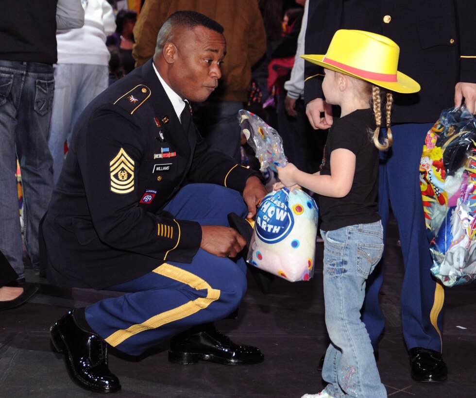Hailey Holt, daughter of Army Spc. Nicholas Holt, a driver for the Army District of Washington,  shows Army Command Sgt. Maj. Mike Williams, U.S. Army District of Washington, her temporary circus tattoo, at the circus March 24 at the Verizon Center in Washington D.C. The show was a salute to military heroes, with many wounded warriors from Walter Reed Army Medical Center and their families in attendance. (U.S. Air Force photo by Senior Airman Torey Griffith)