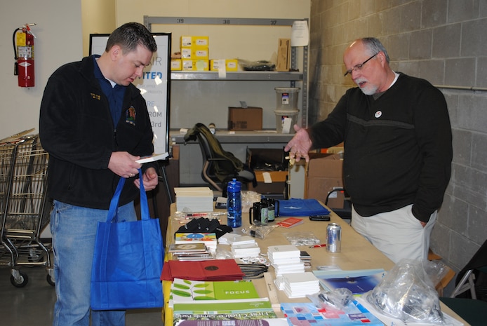 Kevin Sorenson, Outdoor Recreation director (left), takes advantage of the free paper products offered by Wayne Thompson, a paper salesman, at the base service store's Vendor Fair March 23.  The event was held to give local companies a chance to showcase their products to  Malmstrom purchase card holders.  (U.S. Air Force photo/Airman Cortney Hansen)