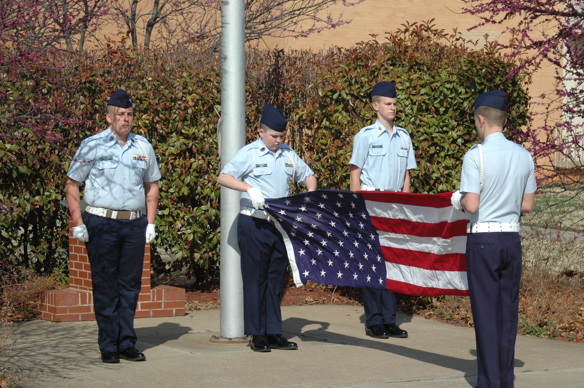 The Grove Composite Squadron team members, from left, Cadets Chief Master Sgt. Benjamin Goodman, Senior Master Sgts. Dakota Gray and Marshall Cook and Senior Airman Justus Taylor demonstrate their ability to lower and fold American flag for this part of the competition. (Air Force photo by Kathy Paine)