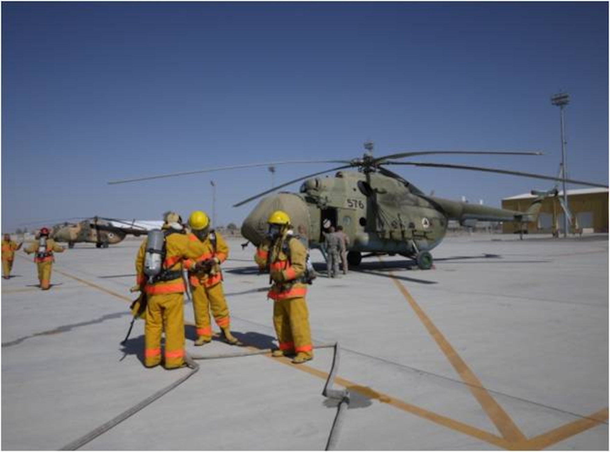 KHANDAR, Afghanistan - On March 24, members of Kandahar Air Wing Firefighters clean-up after a real-time fire exercise evaluating the fire department’s proficiency in responding to a Mi-17 aircraft crash at Kandahar Airfield. (U.S. Air Force photo)