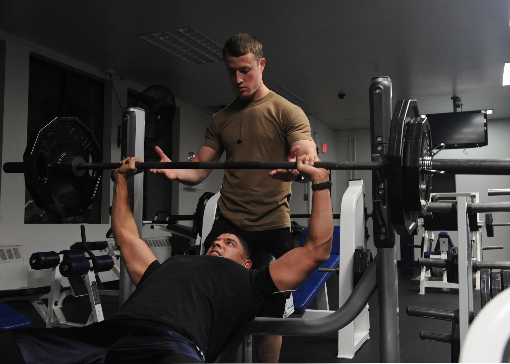 MISAWA AIR BASE, Japan -- Naval Aircrewman Third Class Garrett Bulmer and Pablo Olvera lift weights at the Potter Fitness Center on March 25. The fitness center has returned to normal operations after being configured for earthquake contingency operations.  It is open Monday-Friday 4 a.m.-10 p.m., Saturday and Sunday 8 a.m.-8 p.m. It is still available for limited contingency lodging with 192 cots set up. Physical training reservations have not resumed yet. (U.S. Air Force photo by Senior Airman Chelsea Cummings)