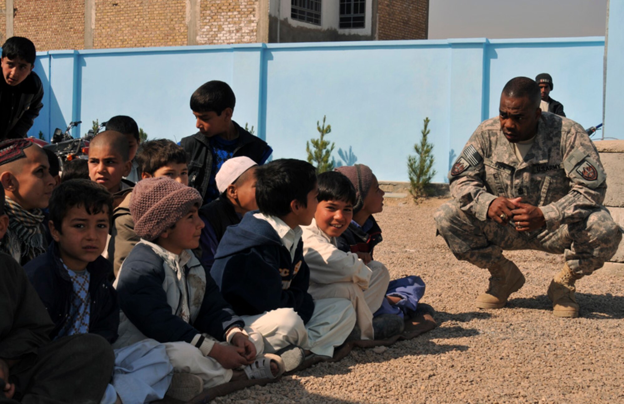 U.S. Army Sgt. Maj. Ira Turner, U.S. Forces-Afghanistan Detachment West sergeant major from Dacula, Ga., talks to Afghan boys, whose new school is set to open in Herat City March 21, 2011, on the Afghan New Year. Sufiabad School will educate about 1,500 students between age 7 and 18 in subjects like: Dari, math, history, geography, religion, English, Arabic, physics and physical education. (U.S. Air Force photo/Tech. Sgt. Kevin Wallace)