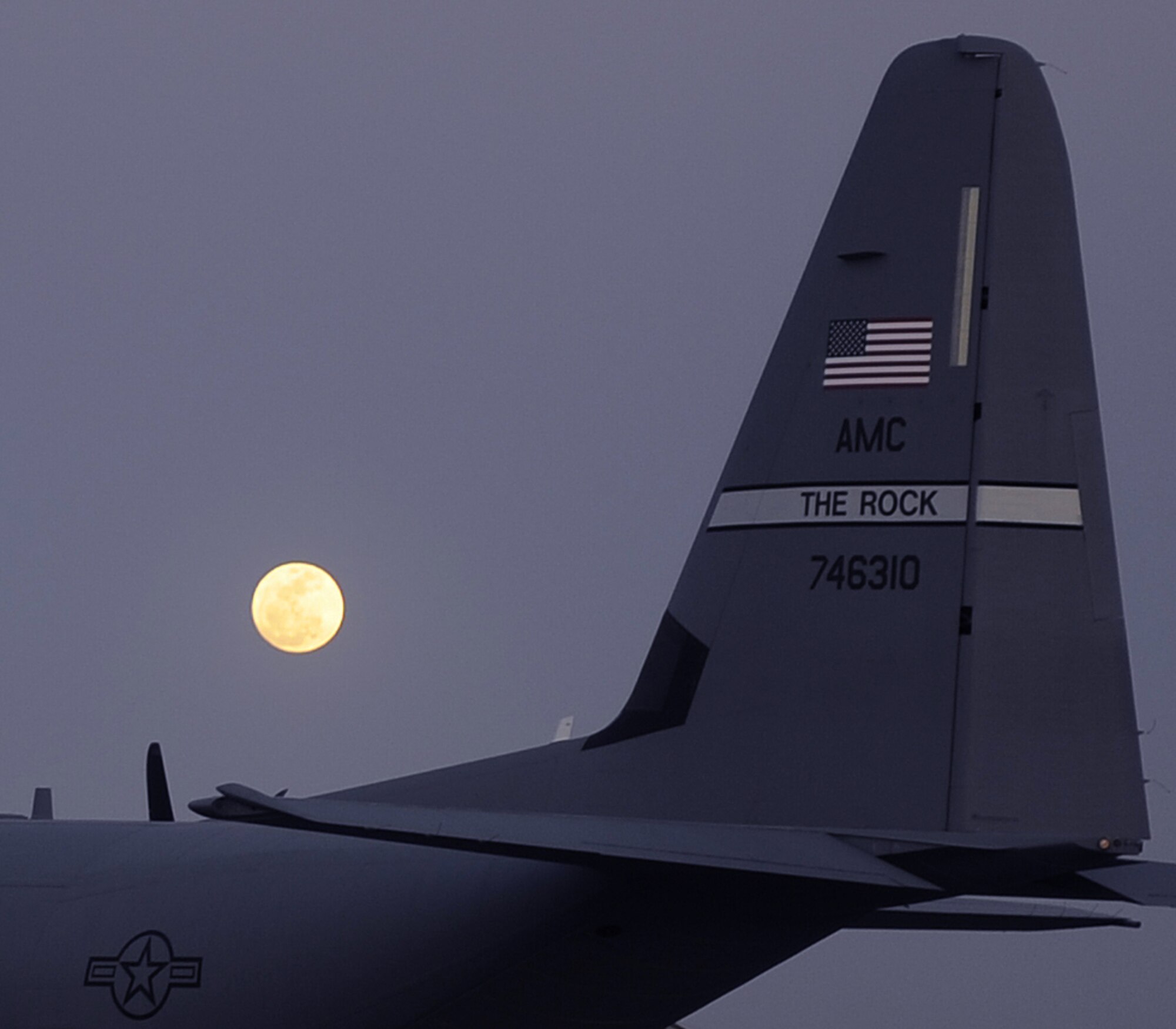 A C-130 Hercules sits on the ramp March 19, 2011, at Kandahar Airfield, Afghanistan. The moons orbit passed closer to the Earth than it has in 18 years making its appearance seem larger than life. The C-130 is assigned to the 772nd Expeditionary Airlift Squadron. (U.S. Air Force photo/Senior Airman Willard E. Grande II)