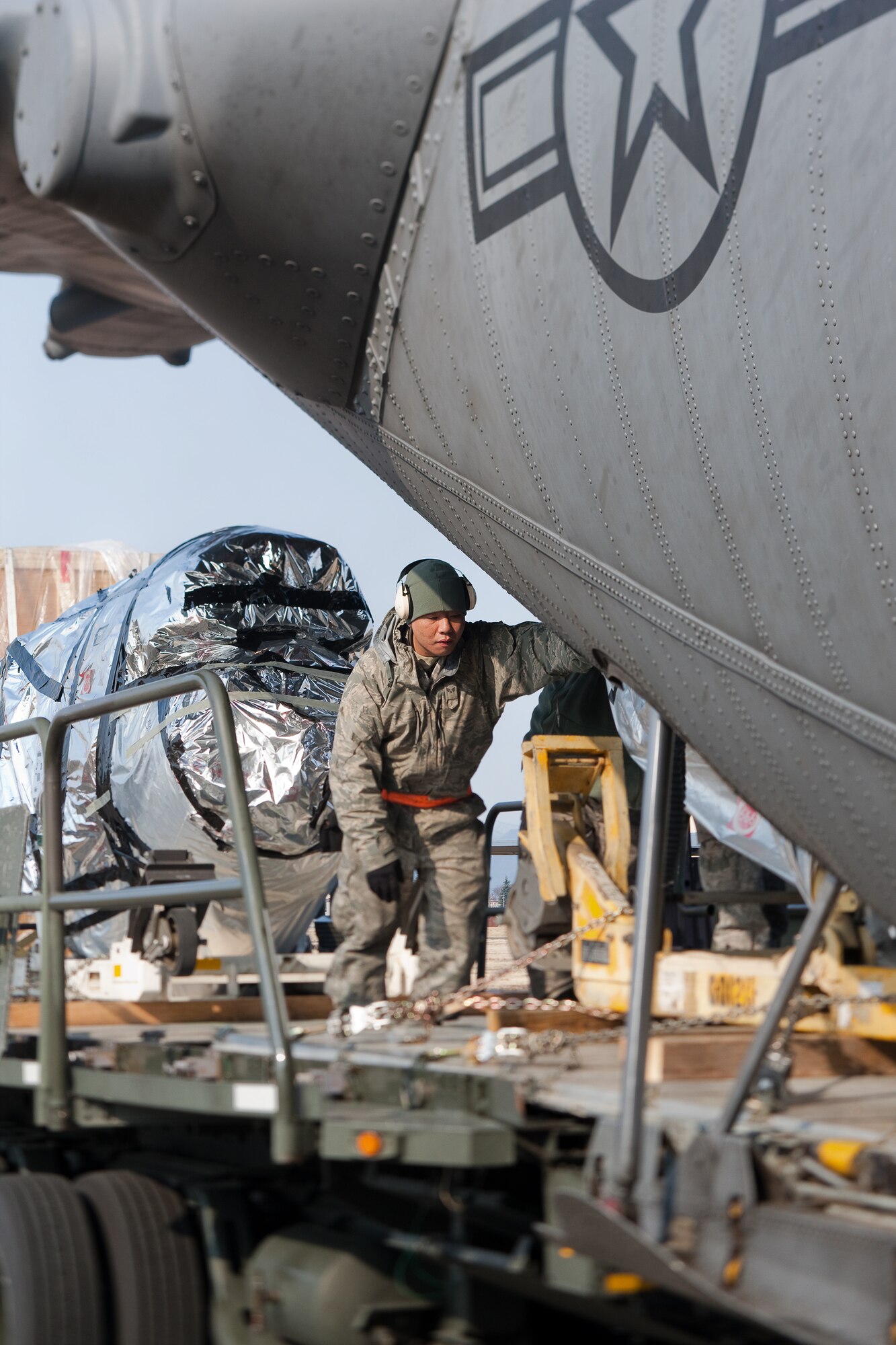 YOKOTA AIR BASE, Japan -- Senior Airman Stanley Quach, 374th Logistics Squadron, loads cargo onto a C-130 Hercules at Yokota Air Base, March 25. This payload will help sustain relief operations taking place at Misawa Air Base. Since the March 11 earthquake and tsunami, Yokota aircrews have worked around the clock delivering vital supplies in support of Operation Tomodachi. (U.S. Air Force photo/Osakabe Yasuo)
