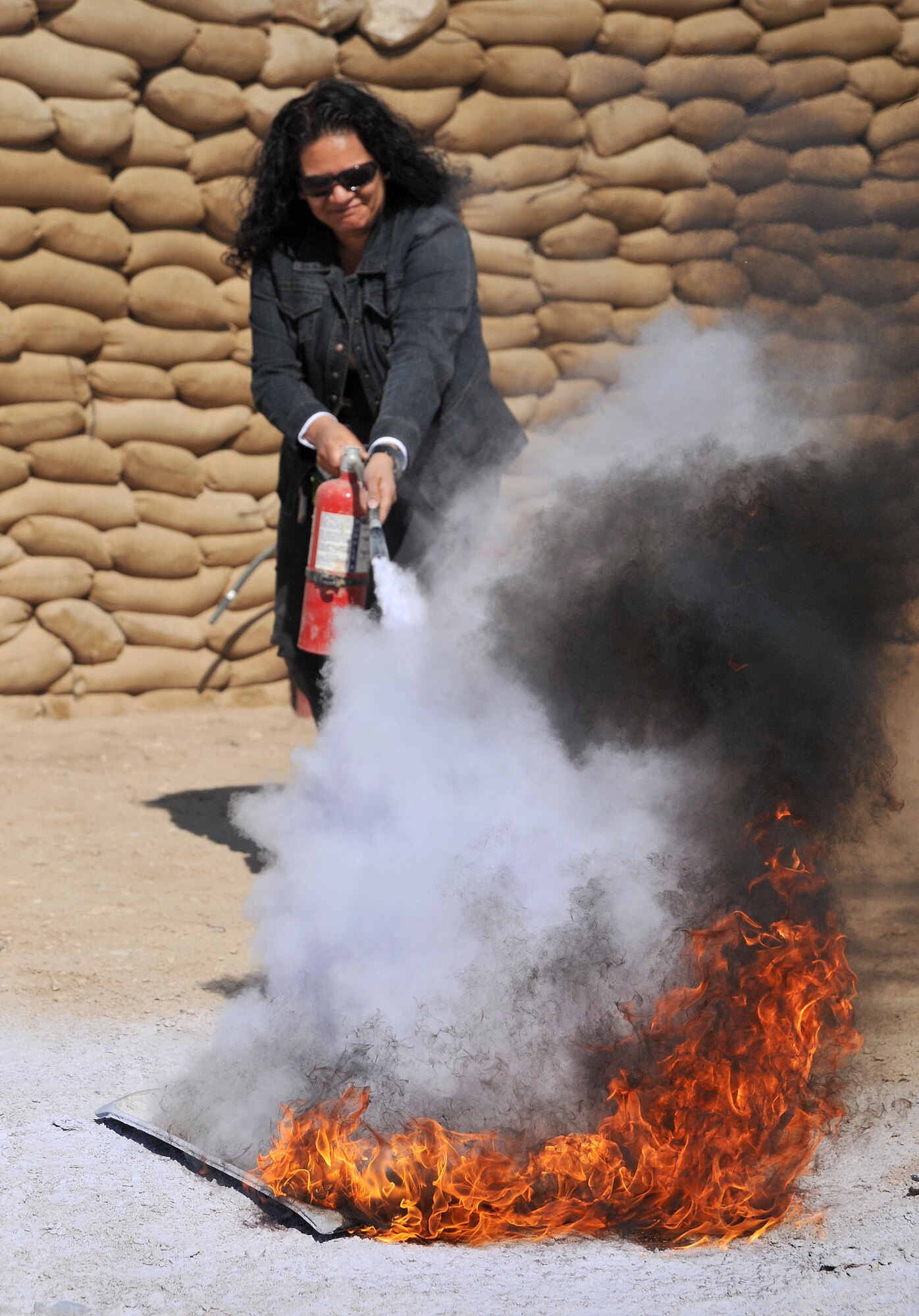 An attendee of fire warden training uses the proper methods to put out a fire with an extinguisher March 2, 2011, at Ali Air Base, Iraq. (U.S. Air Force photo by Senior Airman Andrew Lee/Released)