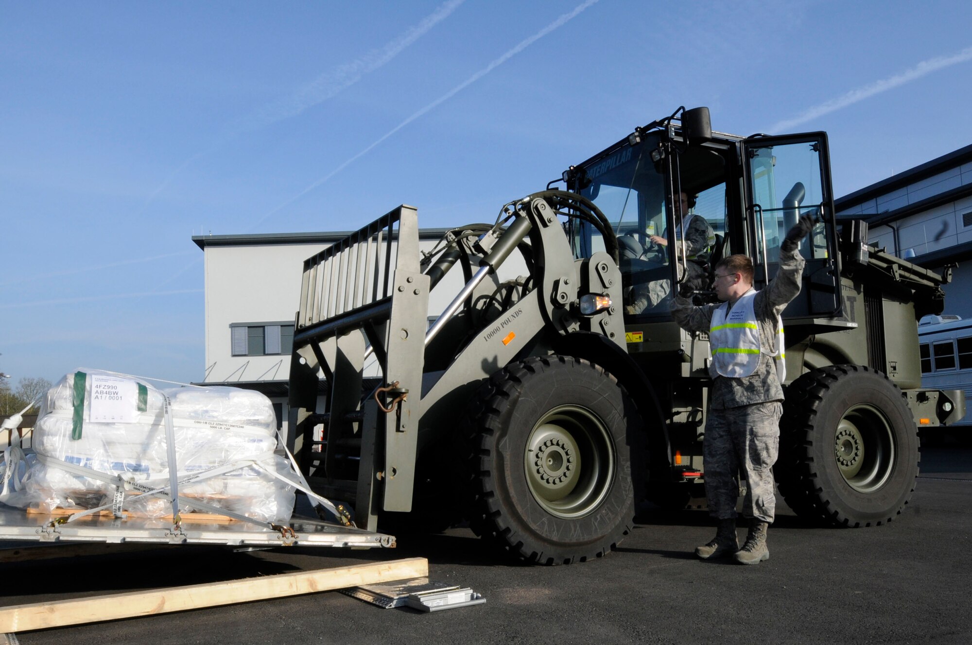 U.S. Air Force Airman 1st Class Mark Rapala directs Senior Airman Zachary Davis, both from the 86th Logistics Readiness Squadron, as he moves a pallet in support of Joint Task Force Odyssey Dawn, Ramstein Air Base, Germany, March 24, 2011. Joint Task Force Odyssey Dawn is the U.S. Africa Command task force established to provide operational and tactical command and control of U.S. military forces supporting the international response to the unrest in Libya and enforcement of United Nations Security Council Resolution (UNSCR) 1973. UNSCR 1973 authorizes all necessary measures to protect civilians in Libya under threat of attack by Qadhafi regime forces. JTF Odyssey Dawn is commanded by U.S. Navy Admiral Samuel J. Locklear, III. (U.S. Air Force photo by Airman Kendra Alba)
