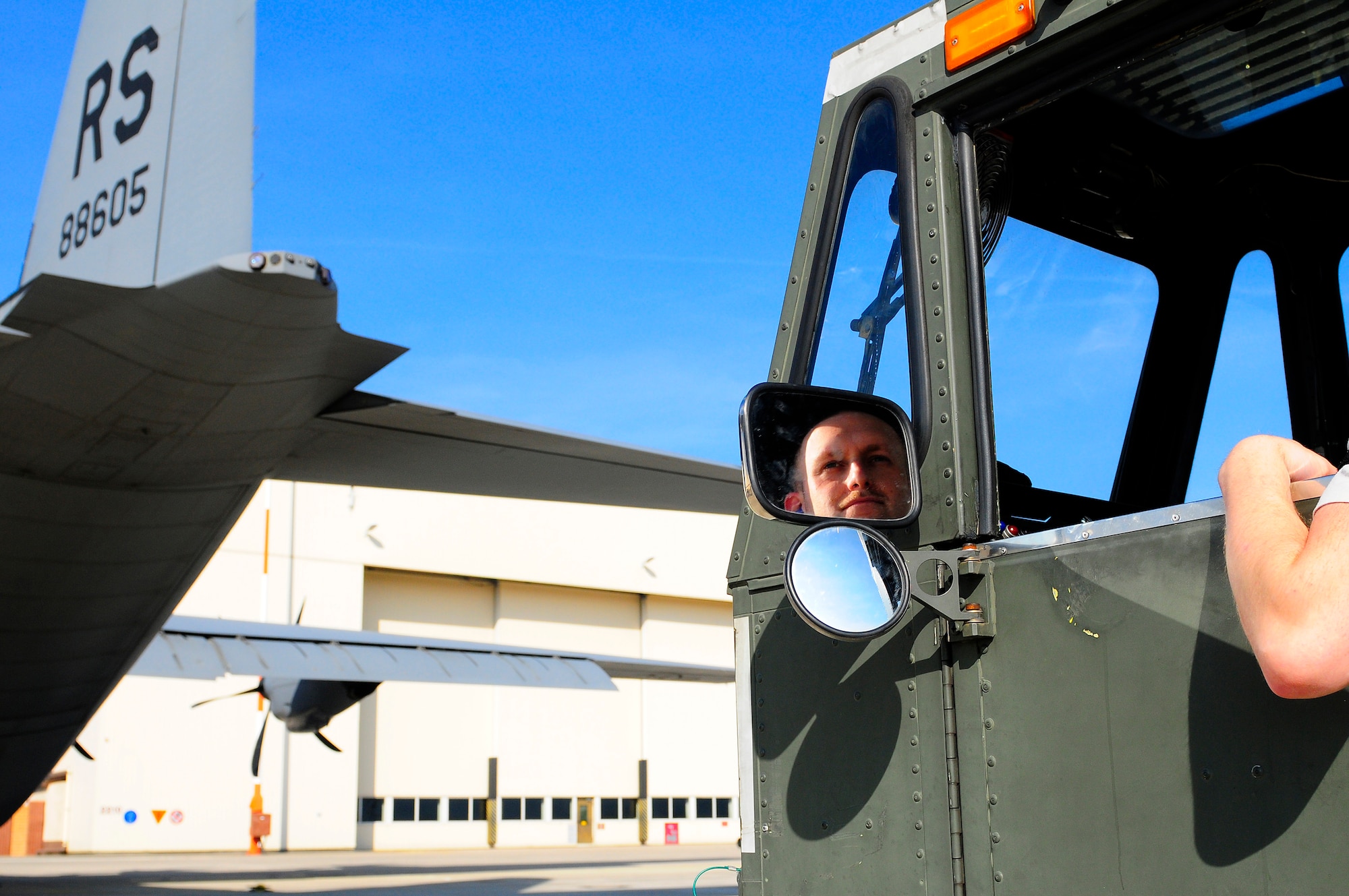 U.S. Air Force Senior Airman Adam Mertz, 721st Aerial Port Squadron, waits to load cargo on a C-130J Super Hercules for its departure in support of Joint Task Force Odyssey Dawn, Ramstein Air Base, Germany, March 24, 2011. Joint Task Force Odyssey Dawn is the U.S. Africa Command task force established to provide operational and tactical command and control of U.S. military forces supporting the international response to the unrest in Libya and enforcement of United Nations Security Council Resolution 1973. UNSCR 1973 authorizes all necessary measures to protect civilians in Libya under threat of attack by Qadhafi regime forces. JTF Odyssey Dawn is commanded by U.S. Navy Admiral Samuel J. Locklear, III. (U.S. Air Force Photo by Airman 1st Class Brea Miller)