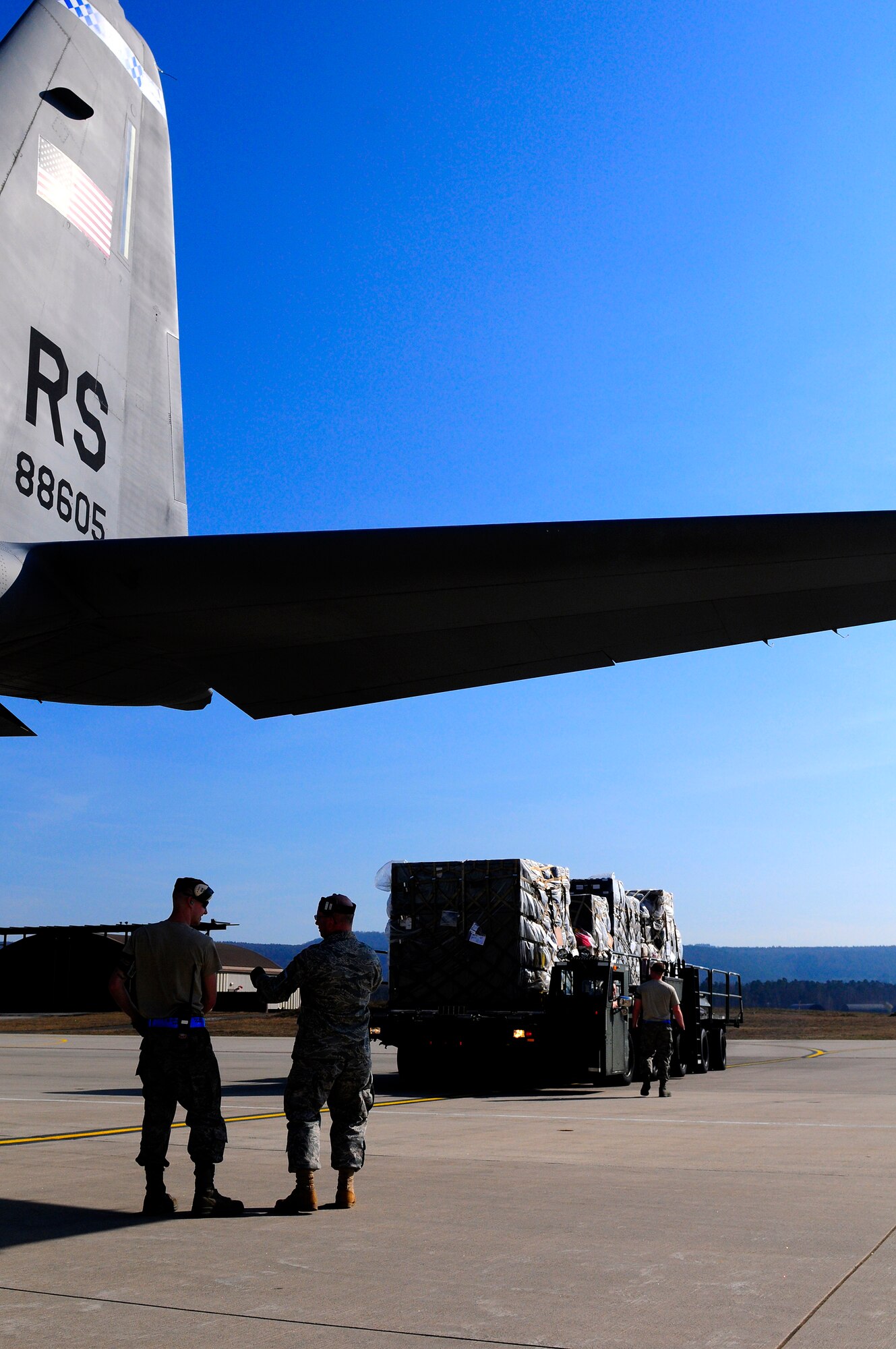 U.S. Air Force Airmen from the 721st Aerial Port Squadron wait to load cargo onto a C-130J Super Hercules for its departure in support of Joint Task Force Odyssey Dawn, Ramstein Air Base, Germany, March 24, 2011. Joint Task Force Odyssey Dawn is the U.S. Africa Command task force established to provide operational and tactical command and control of U.S. military forces supporting the international response to the unrest in Libya and enforcement of United Nations Security Council Resolution 1973. UNSCR 1973 authorizes all necessary measures to protect civilians in Libya under threat of attack by Qadhafi regime forces. JTF Odyssey Dawn is commanded by U.S. Navy Admiral Samuel J. Locklear, III. (U.S. Air Force Photo by Airman 1st Class Brea Miller)