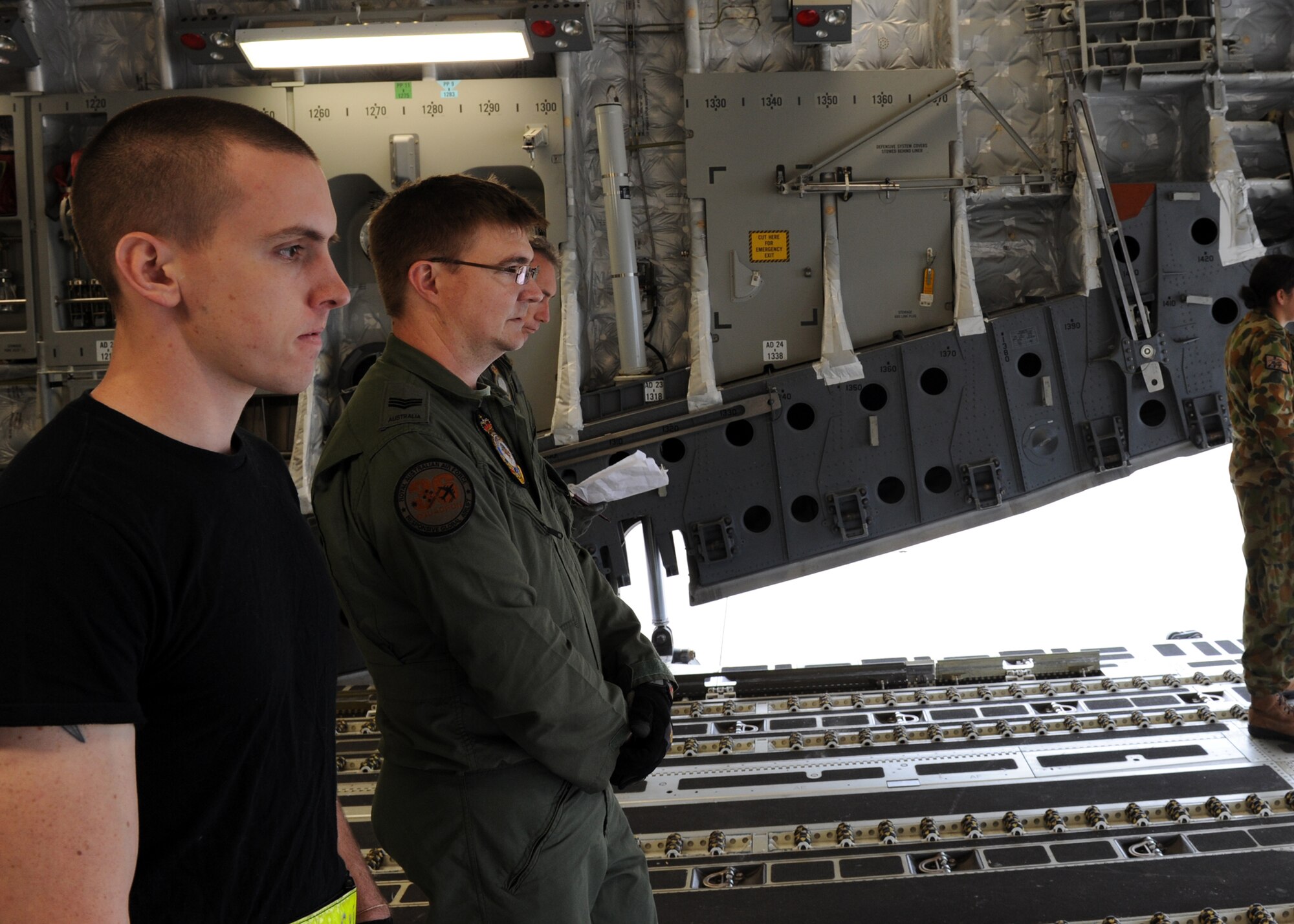 KADENA AIR BASE, Japan -- Senior Airman James Mullennax looks on with Royal Australian Air Force Sergeant Chris Voight as cargo is transported toward a C-17 Globemaster III March 24. Kadena Airmen have had the rare opportunity to work the 36th Squadron and 1st Aircraft Operation Support Squadron from the RAAF during Operation Tomodachi. Airman Mullennax is assigned to the733rd Air Mobility Squadron as an air transportation specialist from Kadena. (U.S. Air Force photo/Senior Airman Michael J. Veloz)
