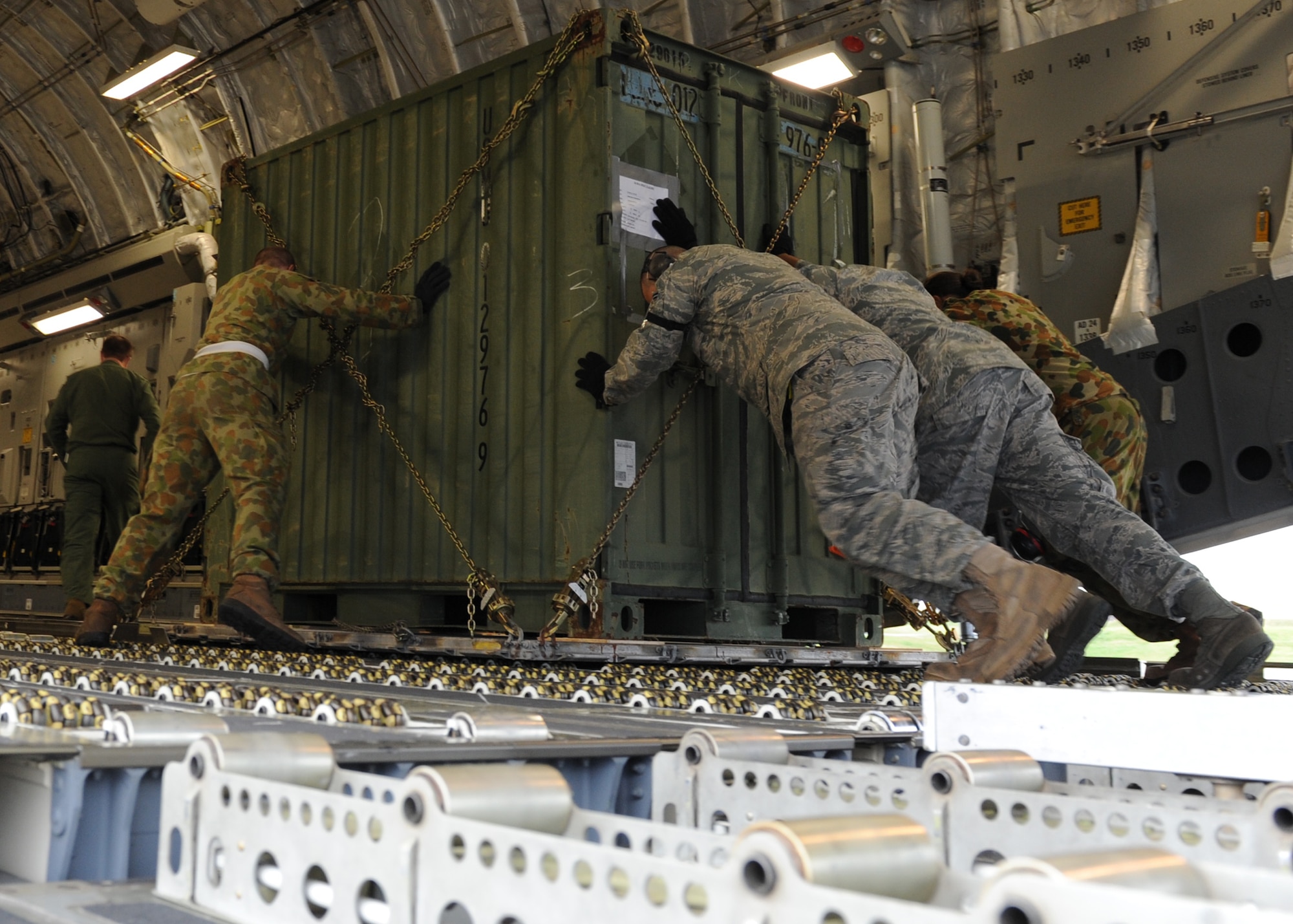 KADENA AIR BASE, Japan -- Members of the Royal Australian Air Force and Airmen form the 733rd Air Mobility Squadron work together loading cargo on to a C-17 Globemaster III March 24. Kadena Airmen have had the rare opportunity to work the 36th Squadron and 1st Aircraft Operation Support Squadron from the RAAF during Operation Tomodachi. (U.S. Air Force photo/Senior Airman Michael J. Veloz)