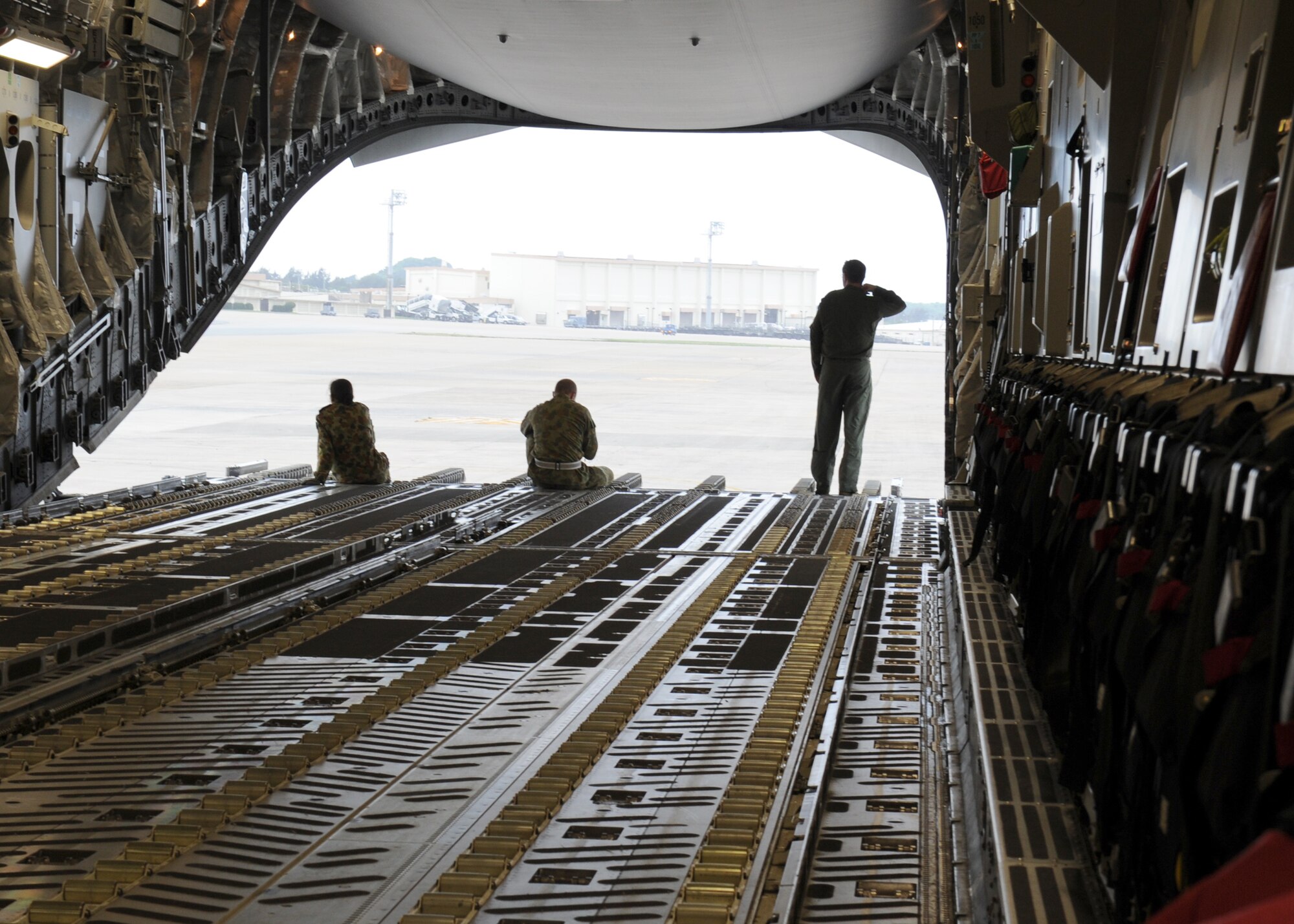 KADENA AIR BASE, Japan -- Members of the Royal Australian Air Force look out from their C-17 Globemaster III prior to loading cargo on to the aircraft March 24. Kadena Airmen have had the rare opportunity to work the 36th Squadron and 1st Aircraft Operation Support Squadron from the RAAF during Operation Tomodachi. (U.S. Air Force photo/Senior Airman Michael J. Veloz)