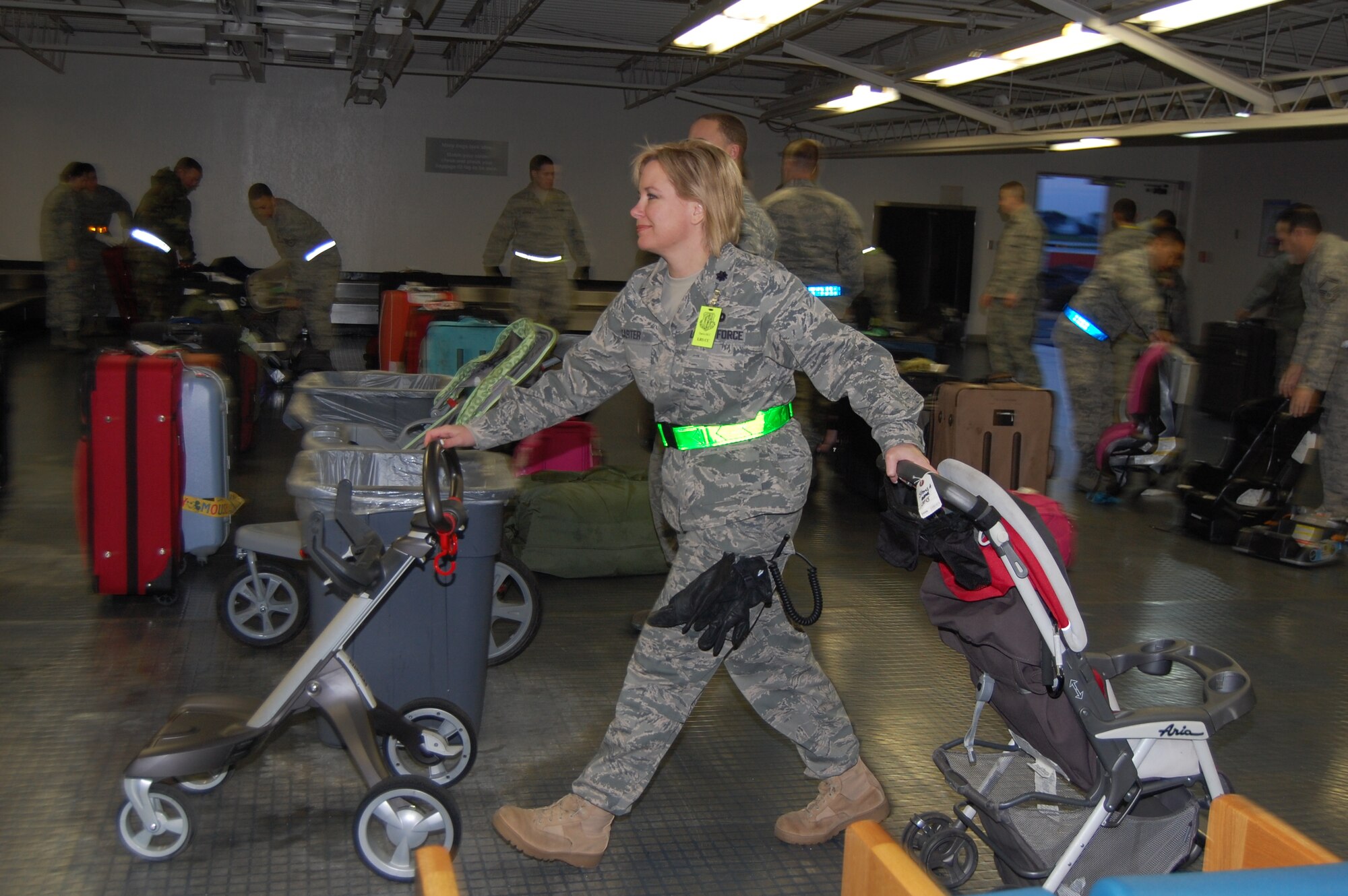 Lt. Col. Rebeccah Carter, commanding officer of the 60th Logistics Readiness Squadron, wheels baby strollers to awaiting parents at the Forward Joint Reception Coordination Center(FJRCC) at Travis Air Force Base March 22. The FJRCC was stood up for Operation Pacific Passage, the Department of Defense mission to provide support for the voluntary return of family members from designated areas in Japan in the aftermath of a deadly earthquake and tsunami that struck Japan March 11. U.S. Navy photo by Melinda Larson 
