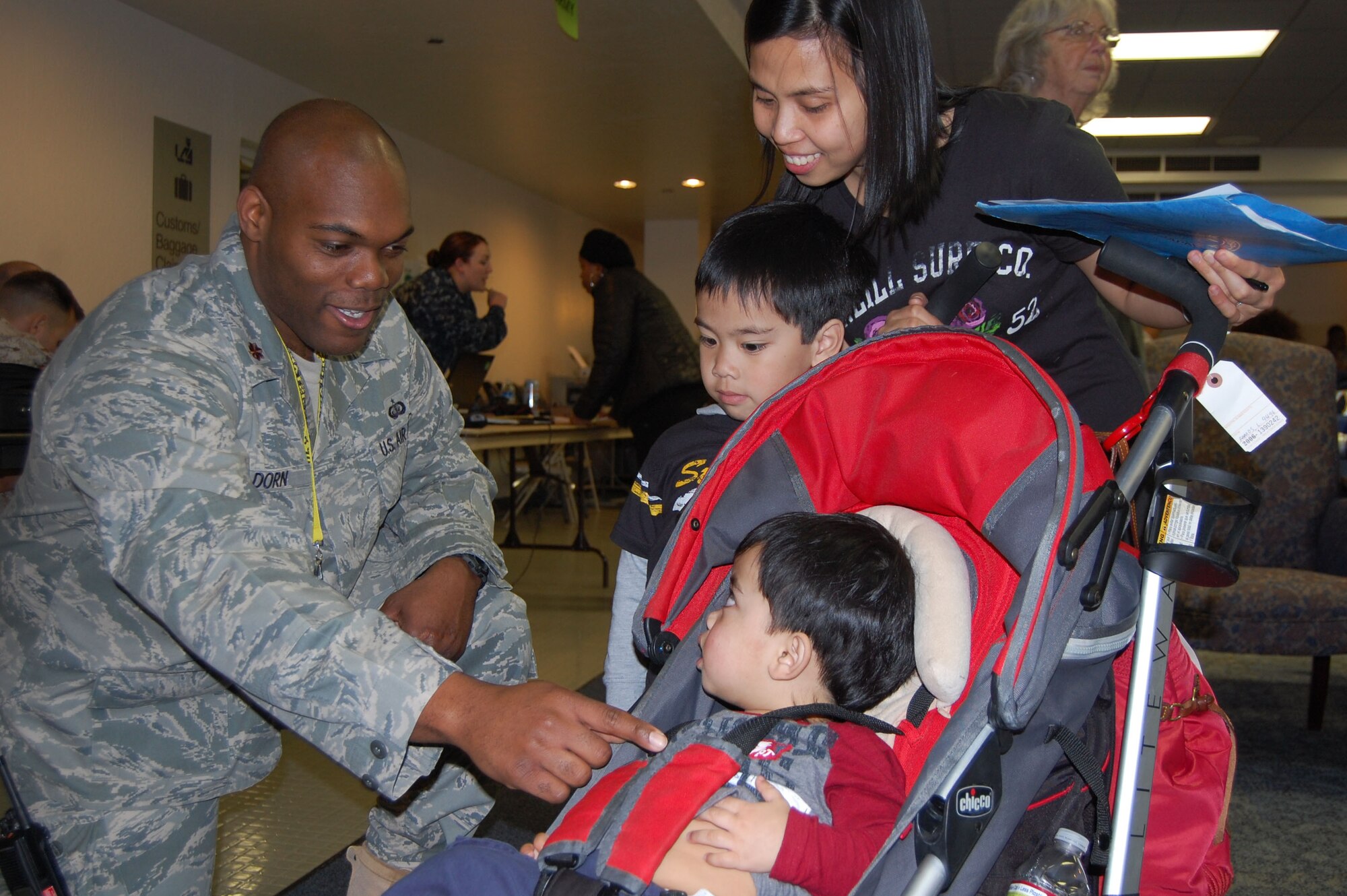 Maj. Craig Dorn, operations officer for the 60th Support Squadron at Travis Air Force Base, greets the Pherigo family upon their arrival from Yokosuka, Japan. The Pherigos, along with more than 700 other military family members, arrived at the Travis Air Force Base Forward Joint Reception Coordination Center March 23 during Operation Pacific Passage, the Department of Defense mission to provide support for the voluntary return of family members from designated areas in Japan. U.S. Navy
photo by Melinda Larson

