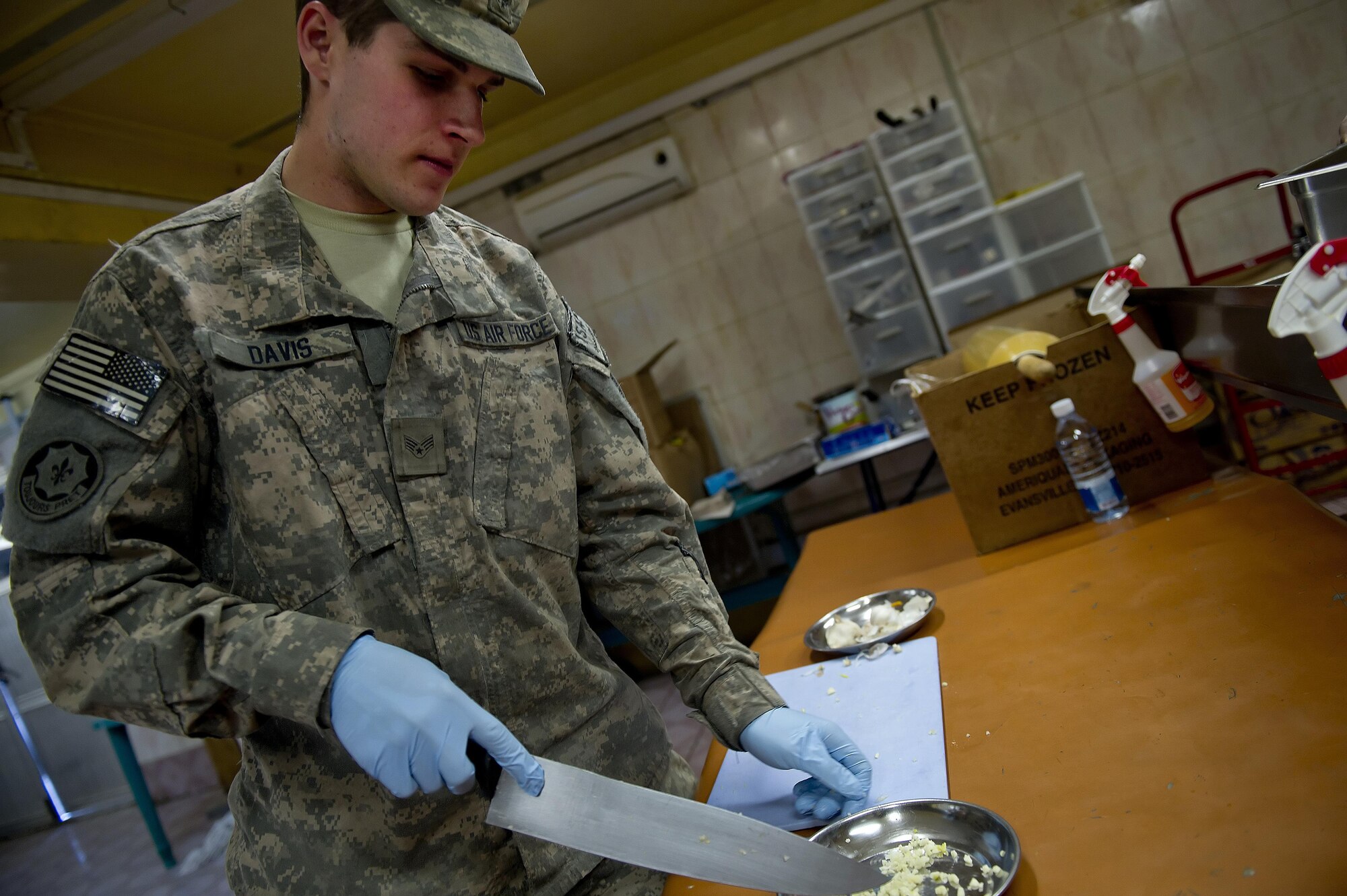Senior Airman Bryant Davis, Provincial Reconstruction Team Zabul cook, chops up a garlic clove as cooks dinner at Forward Operating Base Smart, Afghanistan. Davis is assigned to the dining facility kitchen staff and is responsible for preparing meals for PRT Zabul. PRT Zabul consists of members from the Air Force, Army and other civilian agencies. Davis is deployed from the 375th Force Support Squadron, Scott AFB, Ill. (U.S. Air Force photo/Master Sgt. Adrian Cadiz)