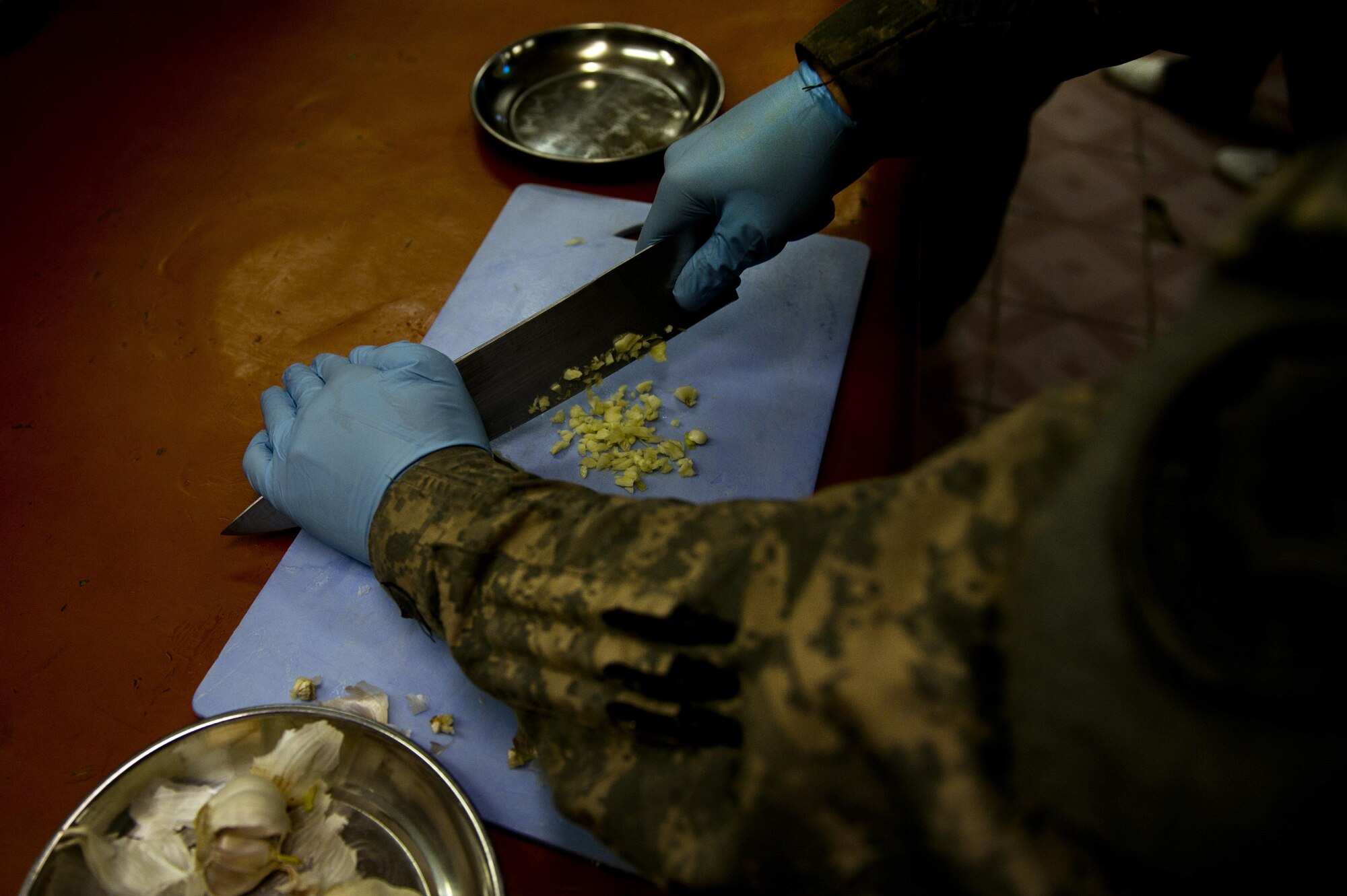 Senior Airman Bryant Davis, Provincial Reconstruction Team Zabul cook, chops up a garlic clove as cooks dinner at Forward Operating Base Smart, Afghanistan. Davis is assigned to the dining facility kitchen staff and is responsible for preparing meals for PRT Zabul. PRT Zabul consists of members from the Air Force, Army and other civilian agencies. Davis is deployed from the 375th Force Support Squadron, Scott AFB, Ill. (U.S. Air Force photo/Master Sgt. Adrian Cadiz)