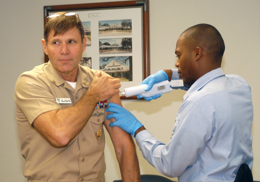 Navy Petty Officer 1st Class Darrell Mangham, right, administers a flu shot to Navy Command Master Chief Joseph Vulkovcan at Naval Air Station Whiting Field. Mangham shared his preventive medicine expertise with Afghan national security forces, earning the prestigious 2011 Hunter-Strickland Excellence Award for Deployment Preventive Medicine for his contributions. U.S. Navy photo by Chief Mass Communication Specialist Jay Cope 