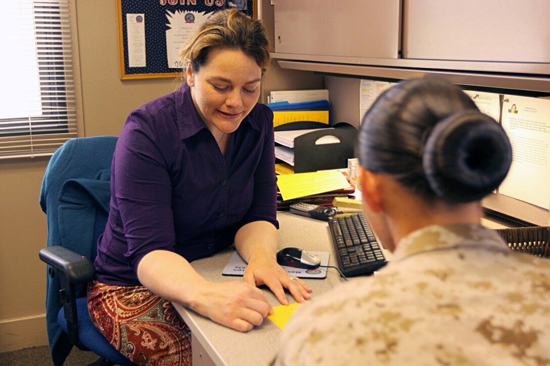 Jeanette Waddell, relief services assistant, Navy Marine Corps Relief Society, gives financial advice to a Marine at Camp Pendleton’s NMCRS facility. The non-profit organization assists active duty and retired Marines, sailors and their families with interest-free loans and grants when they are in need of financial aid.