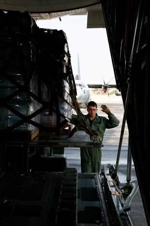 Lance Cpl. Eric M. Wanczak, a Marine Aerial Refueler Transport Squadron 152 loadmaster, guides a forklift operator to get cargo into a C-130 in preparation for a humanitarian mission to Sendai, Japan, as part of Operation Tomodachi here March 25. During this mission, VMGR-152 shuttled approximately 30,000 pounds of water, clothing, food and other miscellaneous relief supplies from Marine Corps Air Station Iwakuni to Sendai, Japan.