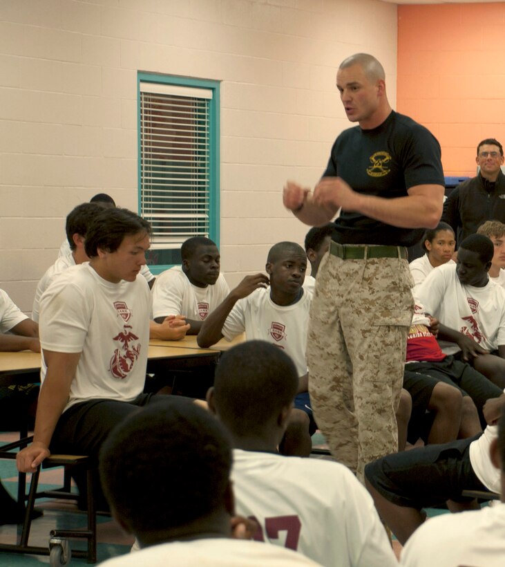 Staff Sgt. Christopher H. Miller, an instructor at the Drill Instructor School, Marine Corps Recruit Depot Parris Island, S.C., talks to a group of football players at a Junior Rank football camp in Jacksonville, Fla., March 26.  Junior Rank invites football players from middle school age to high school seniors to football camps throughout the country.  Marines from the local areas will attend the camps to lead physical training and to mentor the players on leadership and discipline.