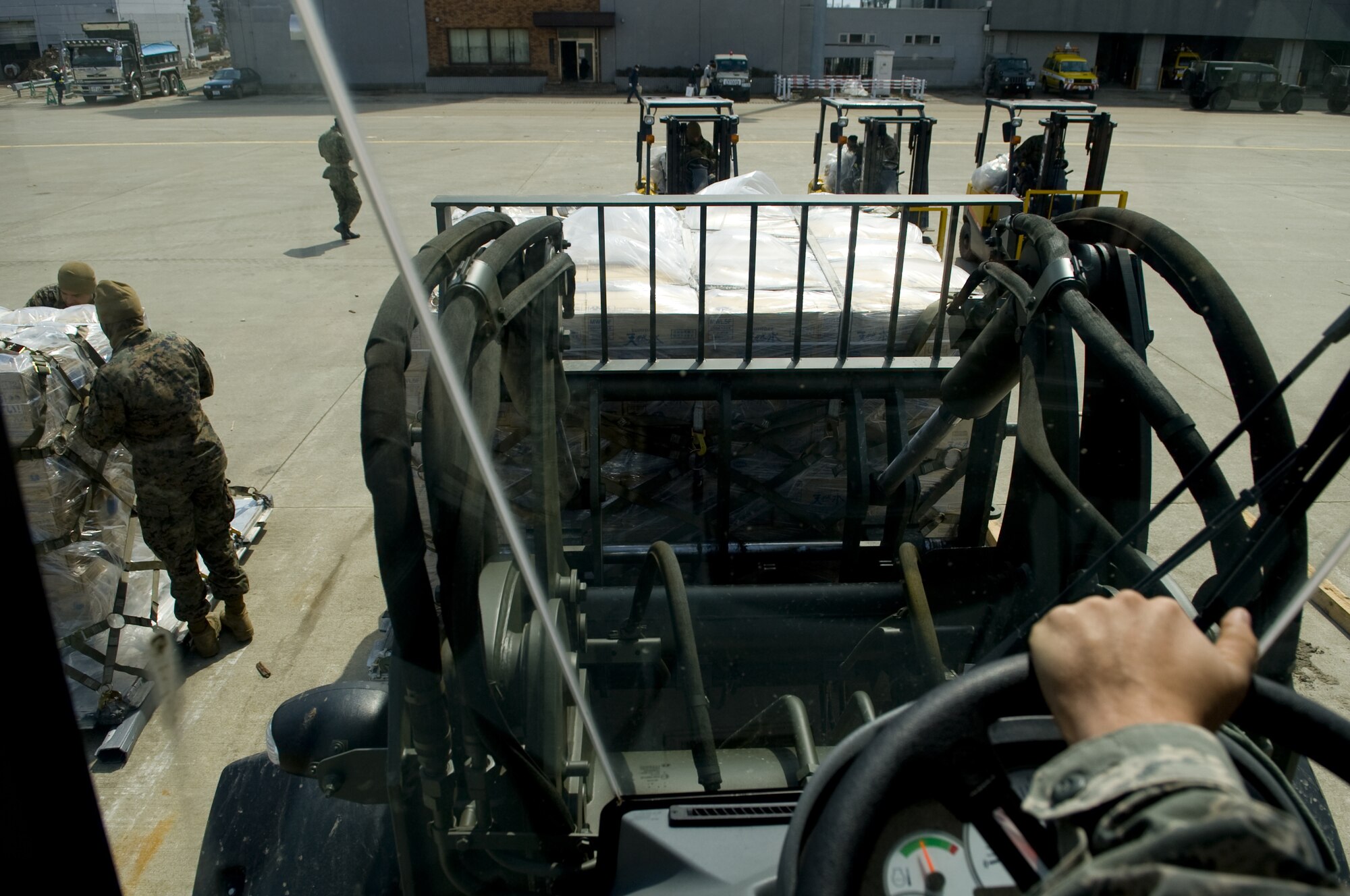 SENDAI AIRPORT, Japan -- Airmen use forklifts to move pallets of water in to a staging area at Sendai Airport, March 26. The water that was airlifted to Sendai Airport is part of the over 1.5 million pounds of water being moved from Yokota Air Base to Northern Japan in support of Operation Tomodachi. (U.S. Air Force photo by/Master Sgt. Jeromy K. Cross)