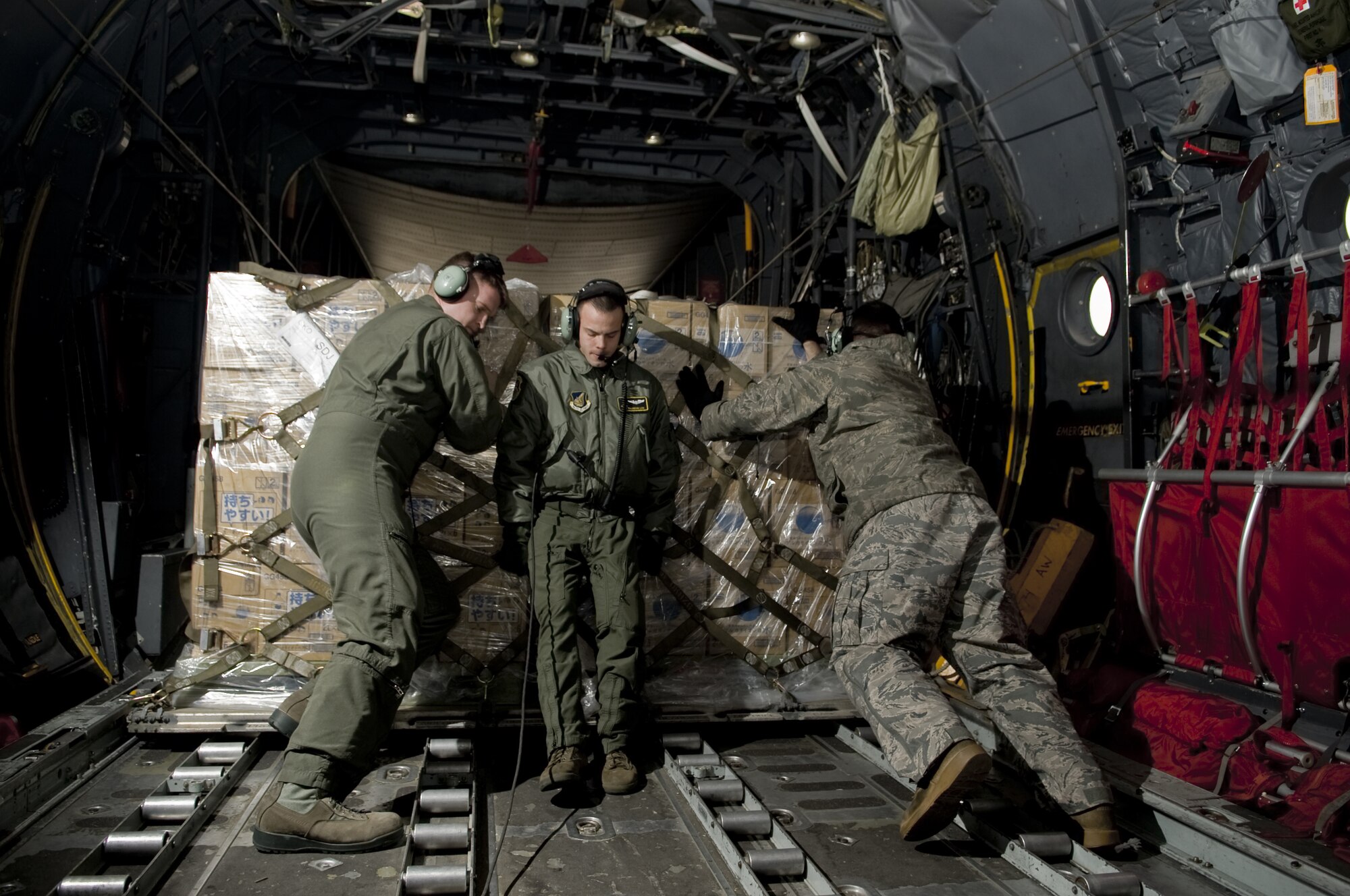 SENDAI AIRPORT, Japan -- Airmen from the 36th Airlift Squadron push a pallet off a C-130H Hurcules at Sendai Airport, March 26. The water that was airlifted to Sendai Airport is part of the over 1.5 million pounds of water being moved from Yokota Air Base to Northern Japan in support of Operation Tomodachi. (U.S. Air Force photo by/Master Sgt. Jeromy K. Cross)