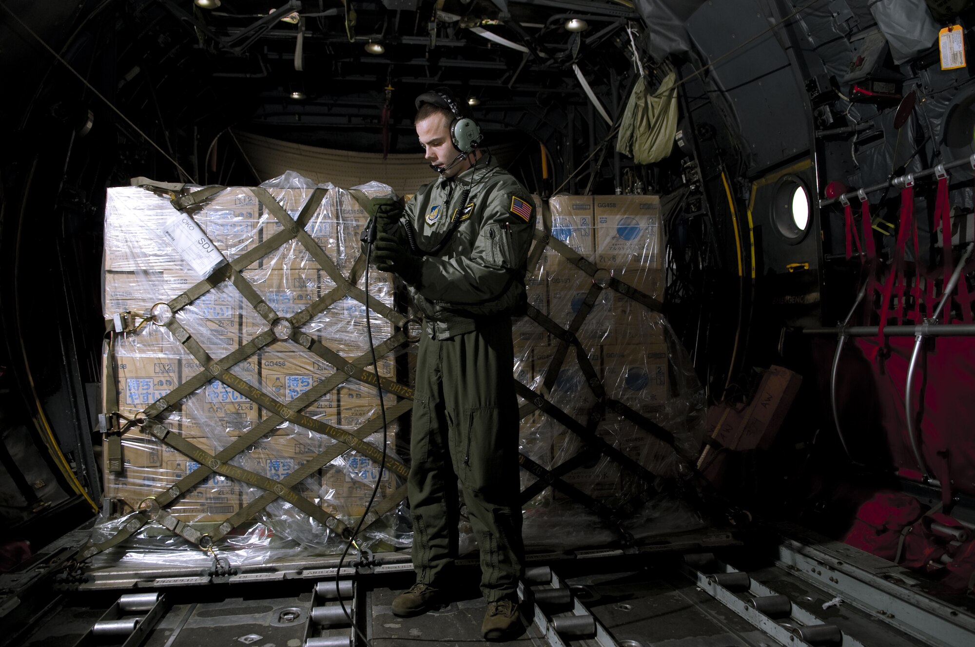 SENDAI AIRPORT, Japan -- Senior Airman Brandon Lee, 36th Airlift Squadron, talks with the rest of the crew before unloading a pallet of water at Sendai Airport, March 26. The water that was airlifted to Sendai Airport is part of the over 1.5 million pounds of water being moved from Yokota Air Base to Northern Japan in support of Operation Tomodachi. (U.S. Air Force photo by/Master Sgt. Jeromy K. Cross)