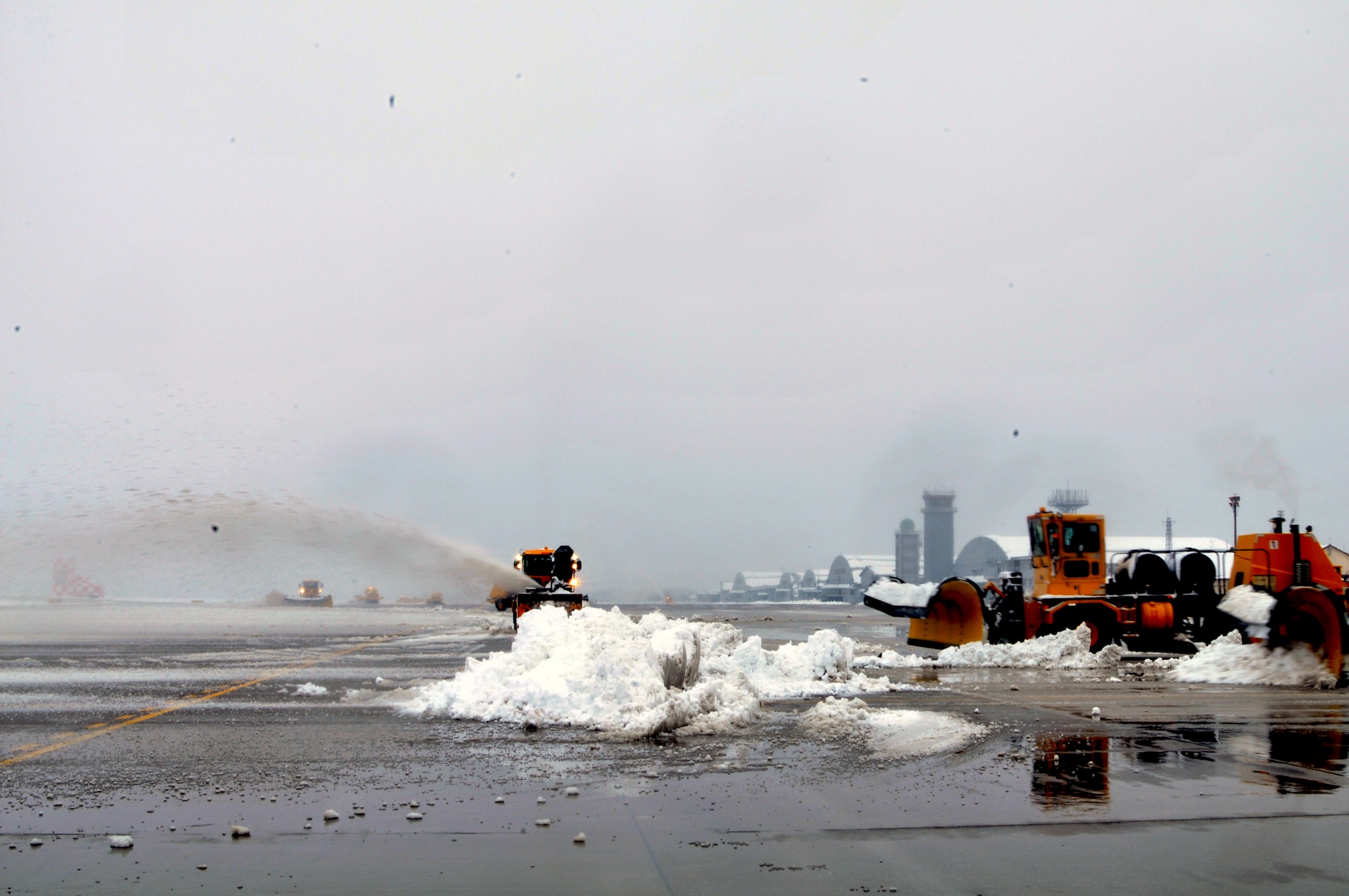 MISAWA AIR BASE, Japan -- Personnel from the 35th Civil Engineer Squadron Horizontal Shop clear the runway here after an overnight snow storm dropped 8.9 inches of snow in a seven hour period.  The runway is being cleared so the base can continue receiving passengers and cargo in support of Operation Tomodachi. (U.S. Air Force photo by Master Sgt. Matthew Osborn/Released)