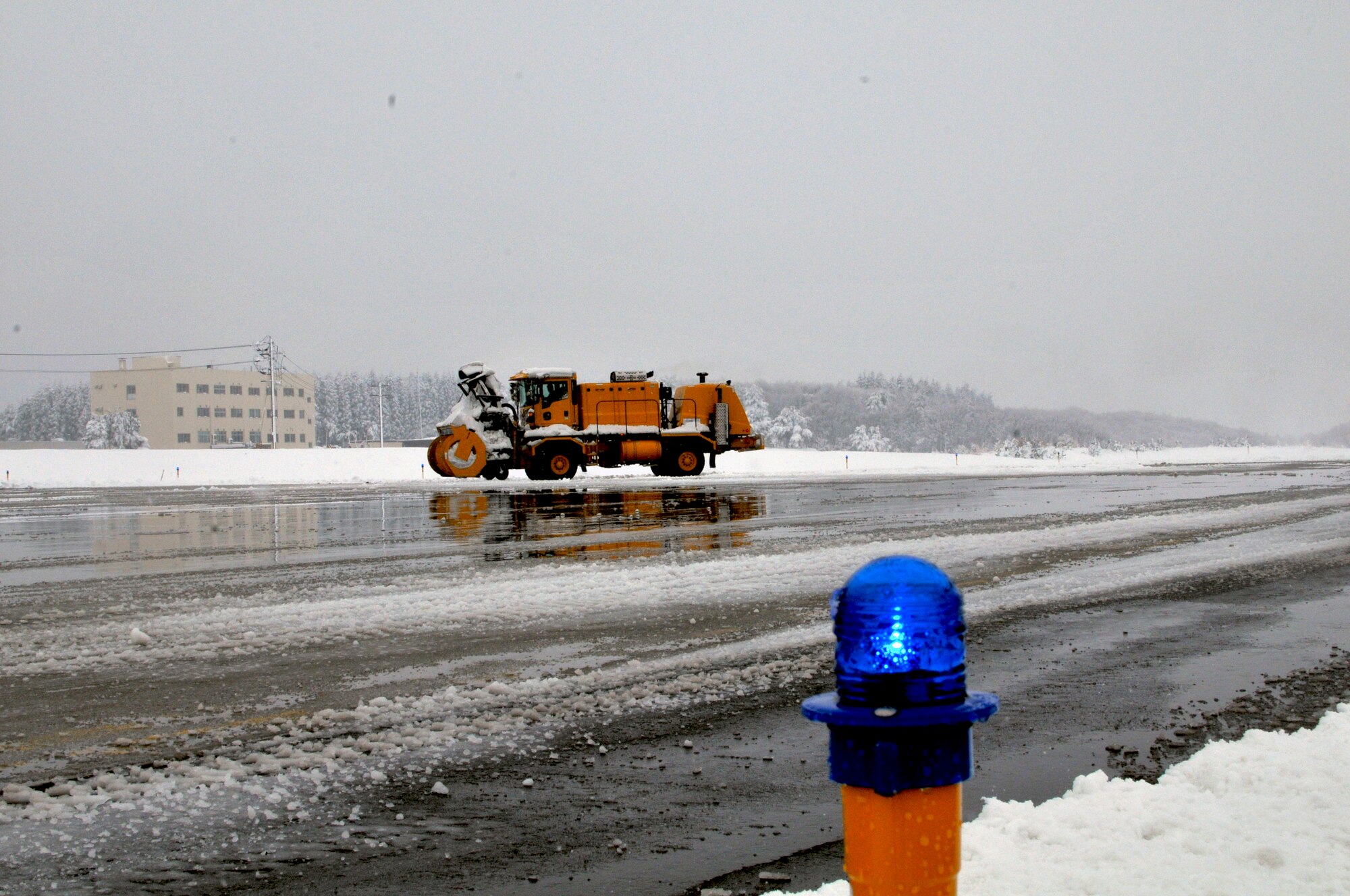 MISAWA AIR BASE, Japan -- Personnel from the 35th Civil Engineer Squadron Horizontal Shop clear the runway here after an overnight snow storm dropped 8.9 inches of snow in a seven hour period.  The runway is being cleared so the base can continue receiving passengers and cargo in support of Operation Tomodachi. (U.S. Air Force photo by Master Sgt. Matthew Osborn/Released)