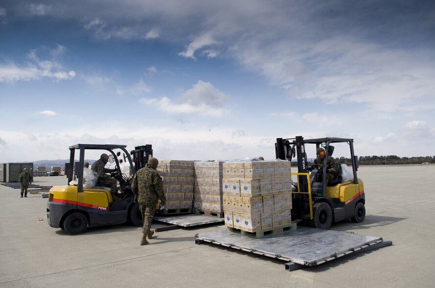 SENDAI AIRPORT, Japan -- U.S. Marines from Combat Logistics Regiment 35, Camp Kinser, Okinawa breakdown pallets of water to be moved on trucks at Sendai Airport, March 26. The water that was airlifted to Sendai Airport is part of the over 1.5 million pounds of water being moved from Yokota Air Base to Northern Japan in support of Operation Tomodachi. (U.S. Air Force photo by/Master Sgt. Jeromy K. Cross)