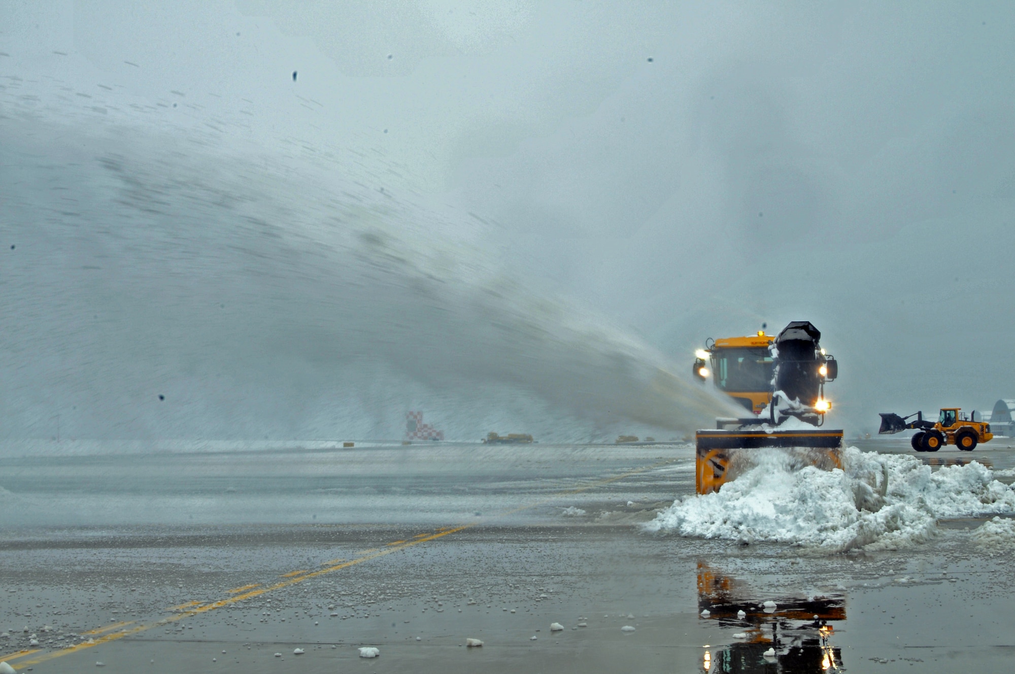MISAWA AIR BASE, Japan -- Personnel from the 35th Civil Engineer Squadron Horizontal Shop clear the runway here after an overnight snow storm dropped 8.9 inches of snow in a seven hour period.  The runway is being cleared so the base can continue receiving passengers and cargo in support of Operation Tomodachi. (U.S. Air Force photo by Master Sgt. Matthew Osborn/Released)