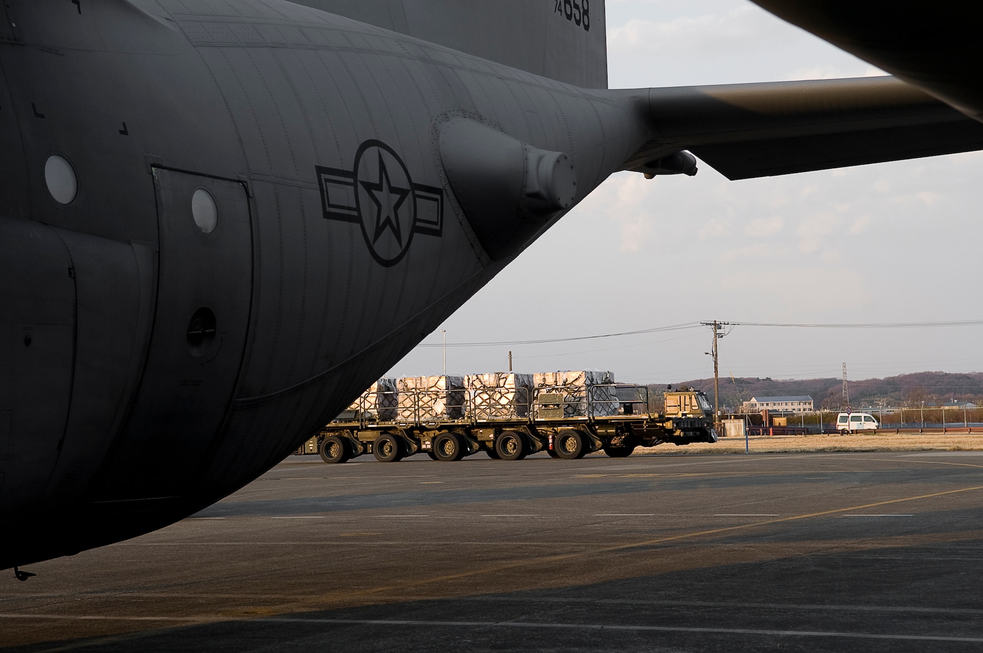 YOKOTA AIR BASE, Japan -- Airmen from the 730th Air Mobility Squadron get a K-Loader of water pallets ready to be flown by the 36th Airlift Squadron's C-130H Hurcules here March 25. Together the two squadrons will be moving more than 1.5 million pounds of water to be airlifted in support of Operation Tomodachi. (U.S. Air Force photo by/Master Sgt. Jeromy K. Cross)