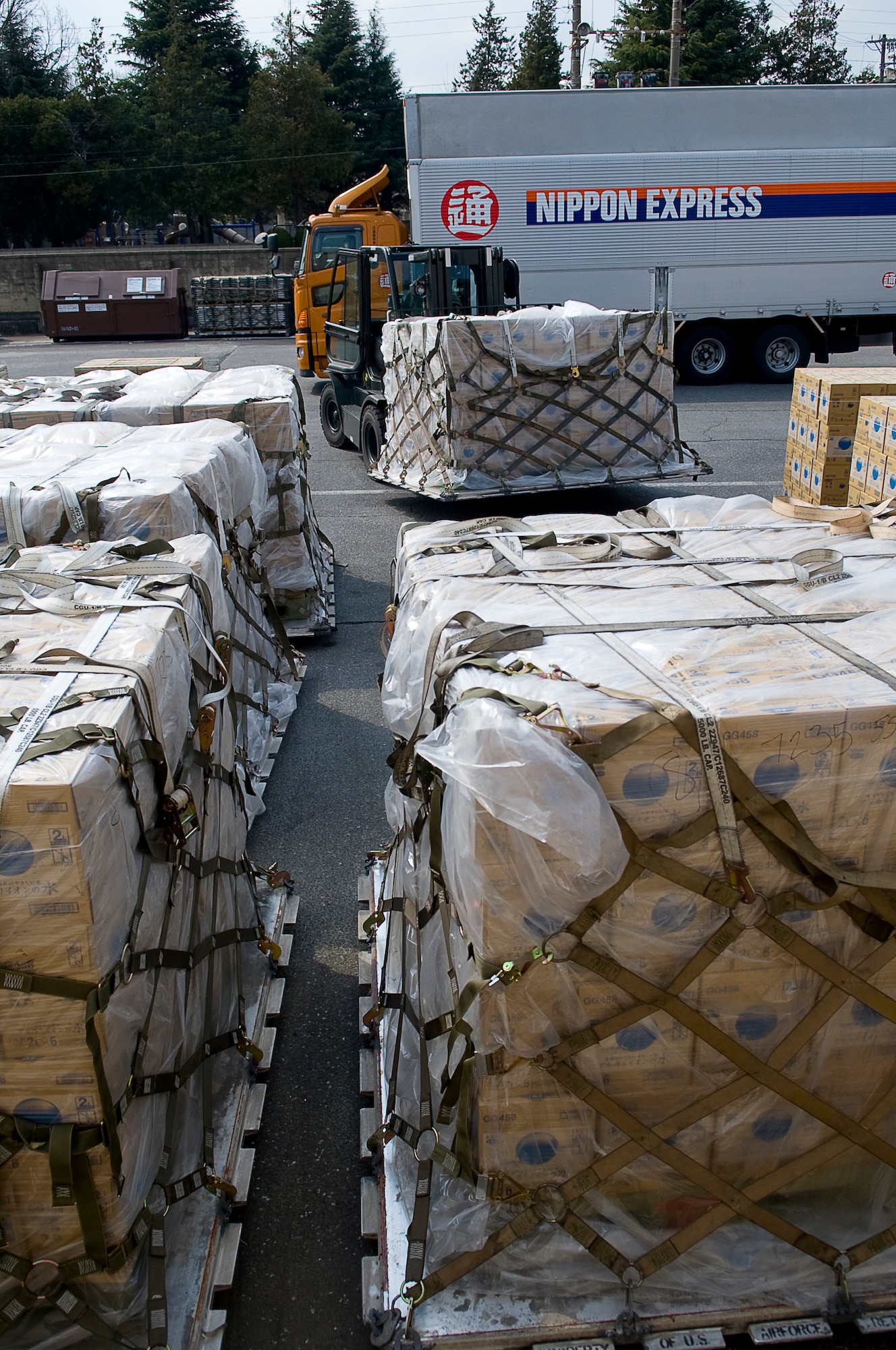 YOKOTA AIR BASE, Japan -- Airmen from the 730th Air Mobility Squadron unload pallets of water from a Japanese commercial truck and build flight ready pallets here March 25. The Airmen of the 730th AMS have unload more than 1.5 million pounds of water to be airlifted in support of Operation Tomodachi. (U.S. Air Force photo by/Master Sgt. Jeromy K. Cross)