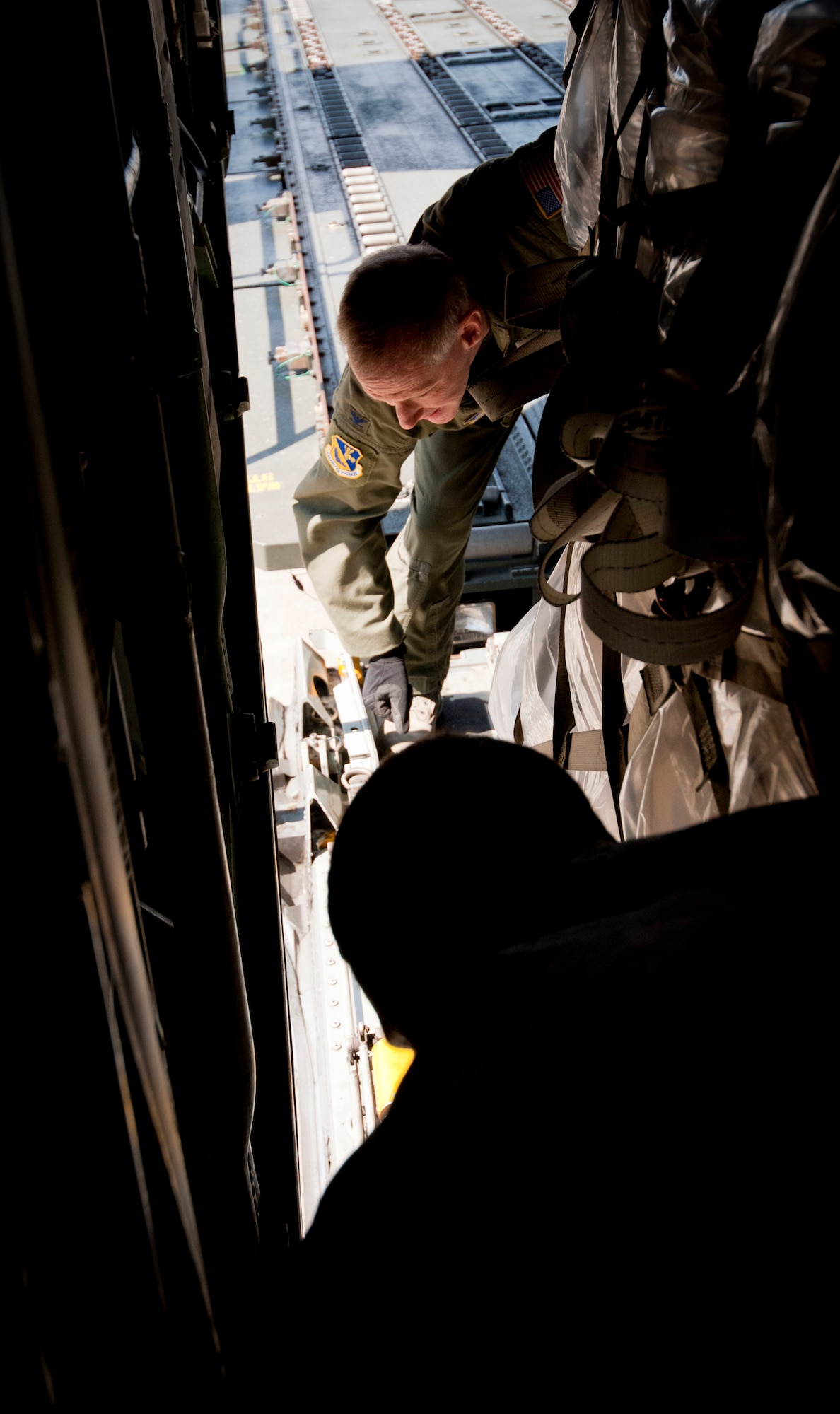YOKOTA AIR BASE, Japan -- Col. Otto Feather, 374th Airlift Wing commander, clamps a pallet of water to the cargo door of a C-130H Hercules at Yokota Air Base, Japan, March 26, 2011. Colonel Feather flew five pallets of potable water to Sendai Airport to be distributed to Japanese citizens in need. (U.S. Air Force photo/Staff Sgt. Samuel Morse)