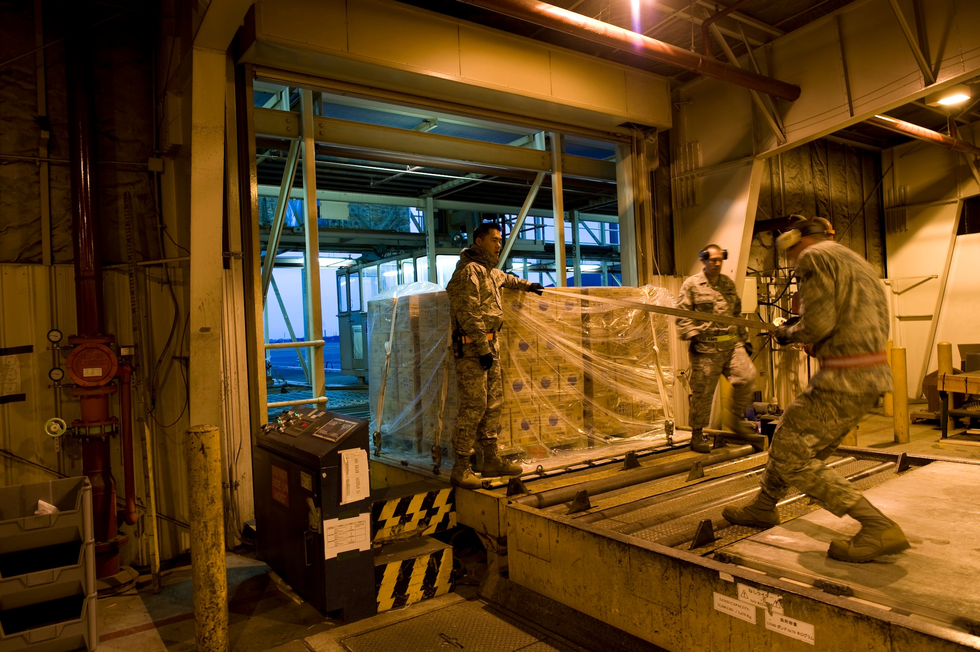 YOKOTA AIR BASE, Japan -- Members of the 730th Air Mobility Squadron and the 374th Logistics Readiness Squadron work together to palletize water at Yokota Air Base, Japan, March 24. The two squadrons worked together to prepare the water for delivery to Japanese citizens in need, in the wake of the devastating earthquake and tsunami March 11. (U.S. Air Force photo/Staff Sgt. Samuel Morse)