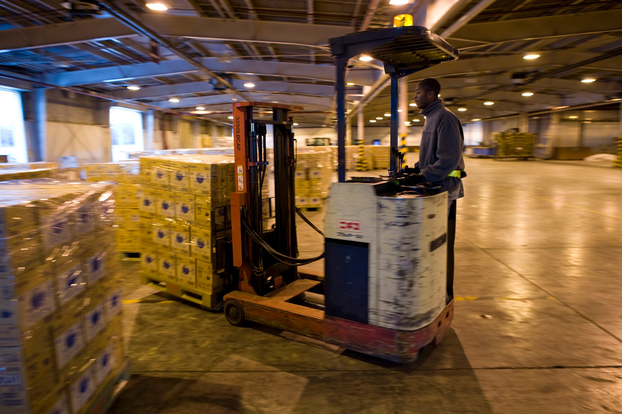 YOKOTA AIR BASE, Japan -- Staff Sgt. Jahmel Sargent, 730th Air Mobility Squadron, drives a forklift at Yokota Air Base, Japan, March 24. Sergeant Sargent and other Airmen of the 730th AMS worked together with the 374th Logistics Readiness Squadron to palletize shipments of water to be airlifted to regions of Japan in need of potable water. (U.S. Air Force photo/Staff Sgt. Samuel Morse)