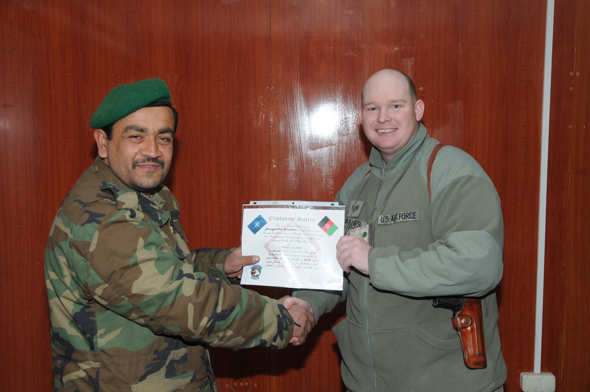 Afghan Air Force Sgt. Yosufzai Hamayattullah receives a certificate for graduating the two-month Basic Explosives Hazards Course on the AAF Base in Kabul, becoming the first weapons safety non-commissioned officer in the AAF. (U.S. Navy photo by Mass Communications Specialist 2nd Class Vladimir Potapenko)