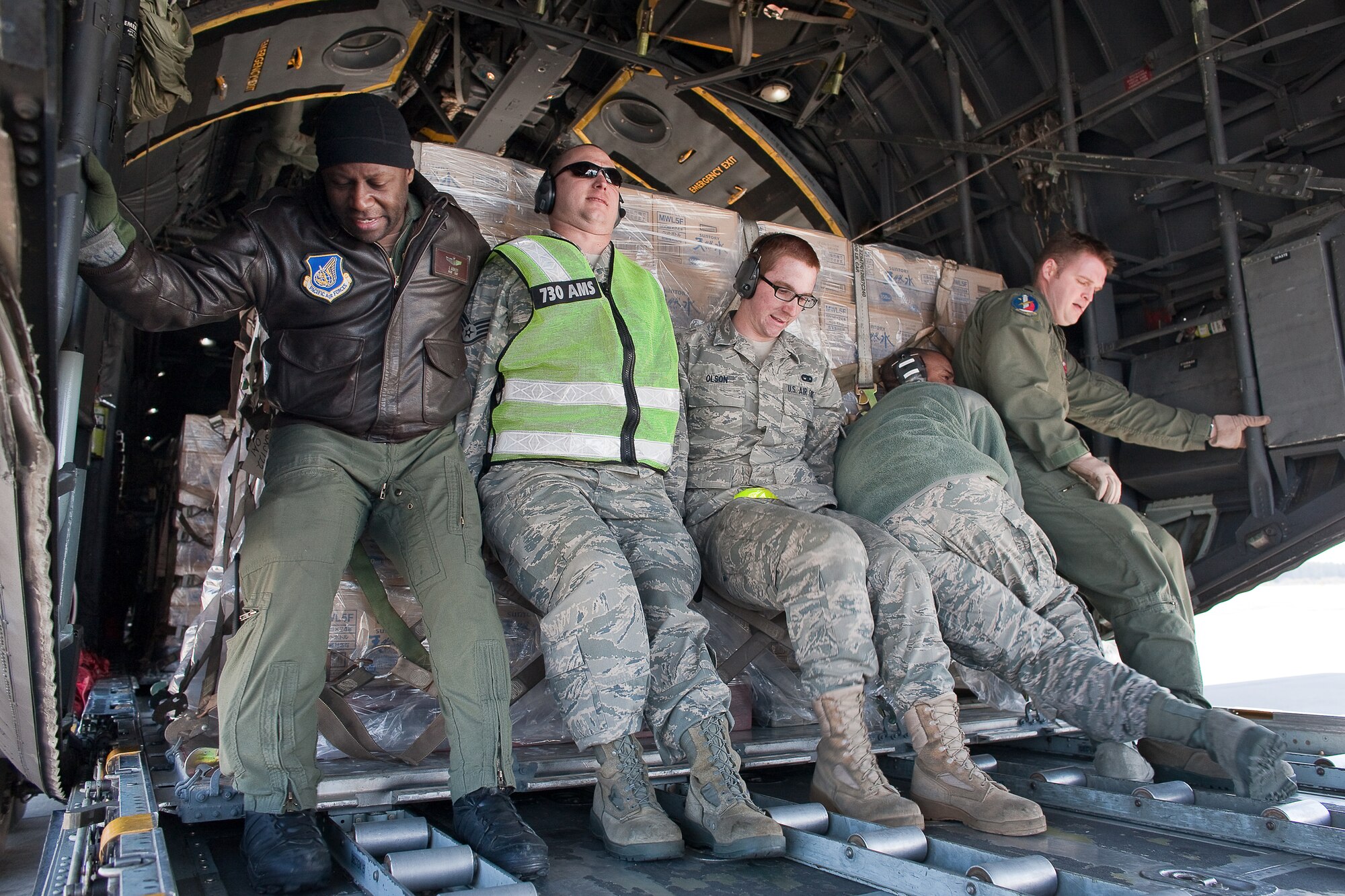 YOKOTA AIR BASE, Japan -- Members from the 730th Air Mobility Squadron and a loadmaster from the 36th Airlift Squadron load five pallets of bottled water to a C-130 Hercules at Yokota Air Base, Japan. Two C-130s from the 36th Airlift Squadron made three trips each to deliver 180,000 pounds of water to Sendai, March 26, as part of a larger mission headed up by the Government of Japan to deliver one million pounds of fresh drinking water for people in northern Japan. The water was donated by Kounoike-Unyu-Hakushu; Asahi Soft Drink Co. Ltd., Fujisan Factory; Kirin Beverage Co. Ltd, Gotenba Factory, to aid in the relief effort. (U.S. Air Force photo/Osakabe Yasuo)