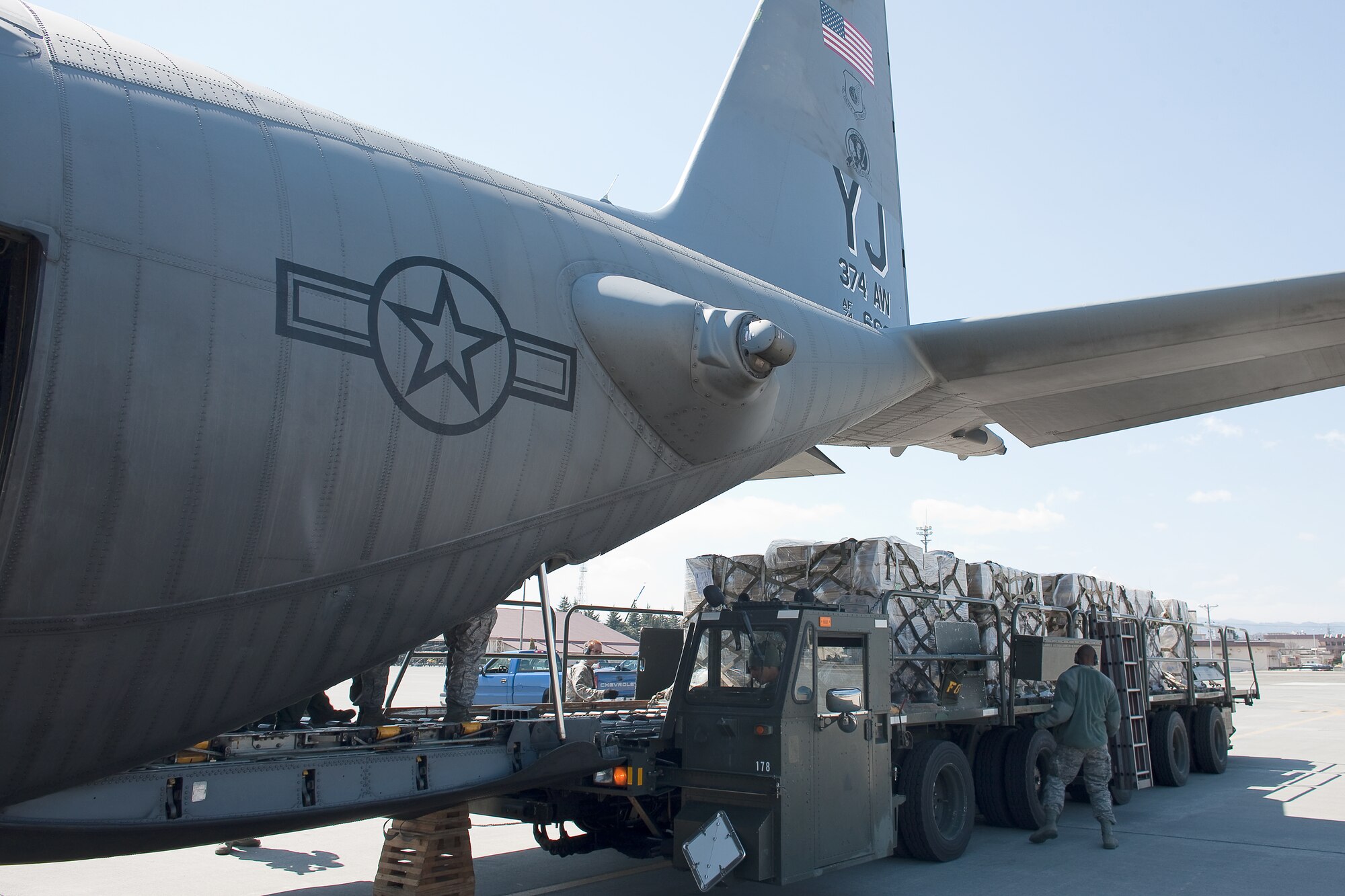 YOKOTA AIR BASE, Japan -- Members from the 730th Air Mobility Squadron load pallets of bottled water to a C-130 Hercules at Yokota Air base, Japan. Two C-130s from the 36th Airlift Squadron made three trips each to deliver 180,000 pounds of water to Sendai, March 26, as part of a larger mission headed up by the Government of Japan to deliver one million pounds of fresh drinking water for people in northern Japan. The water was donated by Kounoike-Unyu-Hakushu; Asahi Soft Drink Co. Ltd., Fujisan Factory; Kirin Beverage Co. Ltd, Gotenba Factory, to aid in the relief effort. (U.S. Air Force photo/Osakabe Yasuo)