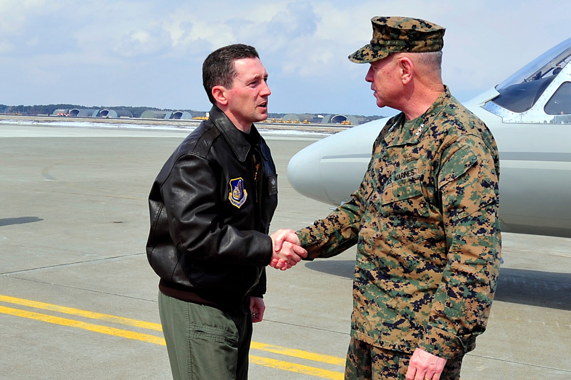 MISAWA AIR BASE, Japan -- U.S. Air Force Col. Michael Rothstein, 35th Fighter Wing commander, greets U.S. Marine Corps Lt. Gen. Kenneth Glueck, Jr., Commanding General, III Marine Expeditionary Force, Marine Corps Base Japan, after he stepped out of his aircraft Mar. 25. General Glueck came for a brief visit here to see the voluntary departure process.  (U.S. Air Force photo by Staff Sgt. Marie Brown\Released)