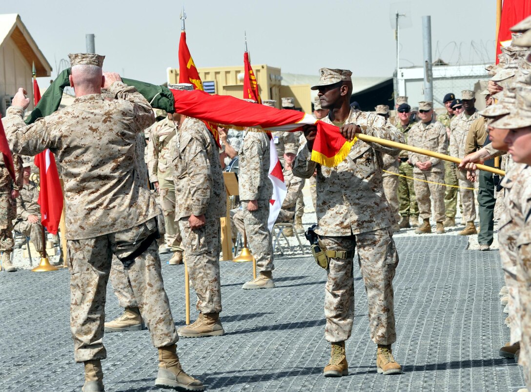 Maj. Gen. John Toolan (left), commanding general of II Marine Expeditionary Force (Forward), and Sgt. Maj. Michael Jones, sergeant major, II MEF (Fwd), unfurl the II MEF colors during a transfer of authority ceremony on Camp Leatherneck, March 26. Toolan assumed command of Regional Command Southwest from Maj. Gen. Richard Mills, commanding general of I MEF (Fwd).