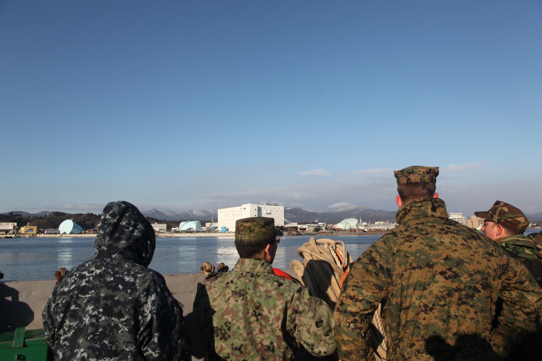U.S. and Japanese Ground Self Defense Force service members view extensive damage to the port here, March 27, the result of the 9.0 earthquake and tsunami.  The 31st Marine Expeditionary Unit and Amphibious Squadron 11 delivered food, water, comfort items and commercial repair vehicles to residents on the isolated island of Oshima using U.S. Navy landing craft, demonstrating the MEU’s expeditionary capabilities in ship-to-shore amphibious operations. Marines and Sailors of the 31st MEU are conducting humanitarian aid and disaster relief missions in northeast Japan in coordination with the Japanese Self Defense Forces.