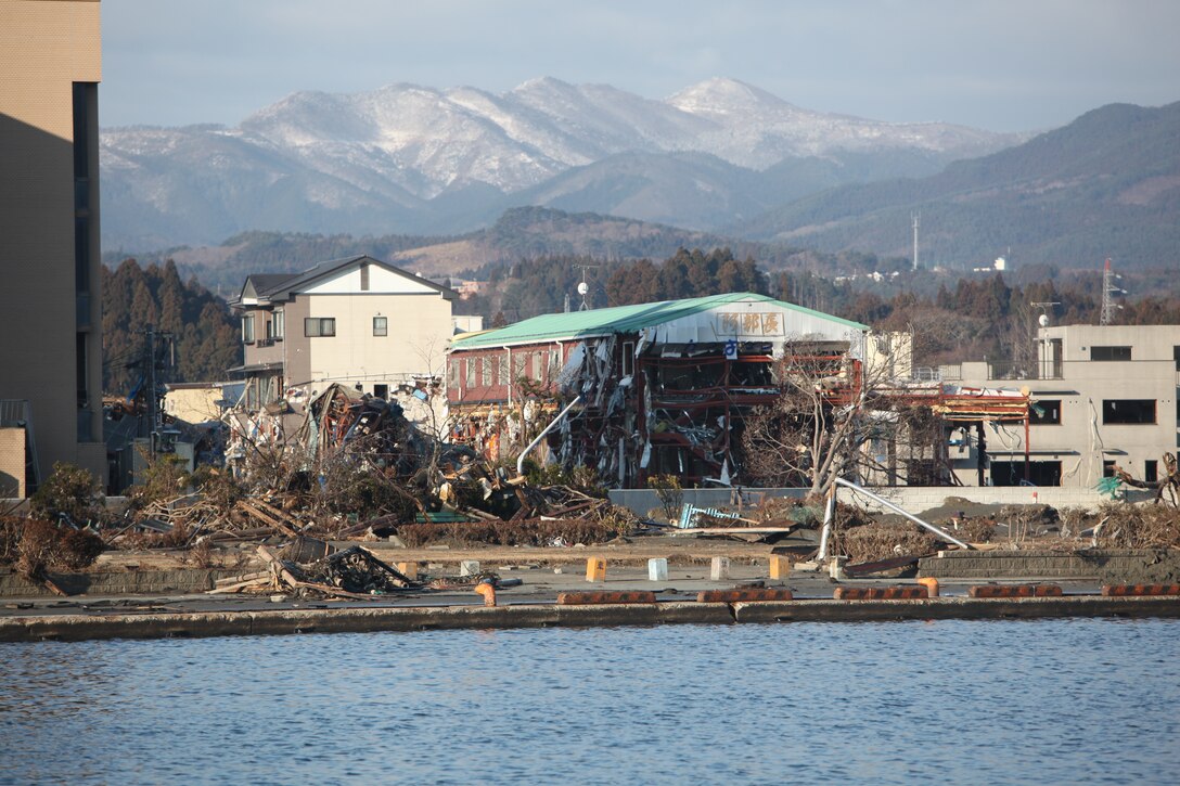 Burned buildings and debris surrounds the port here, March 27, the result of the 9.0 earthquake and tsunami.  The 31st Marine Expeditionary Unit and Amphibious Squadron 11 delivered food, water, comfort items and commercial repair vehicles to residents on the isolated island of Oshima using U.S. Navy landing craft, demonstrating the MEU’s expeditionary capabilities in ship-to-shore amphibious operations. Marines and Sailors of the 31st MEU are conducting humanitarian aid and disaster relief missions in northeast Japan in coordination with the Japanese Self Defense Forces.